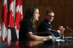 Tiff Macklem listens to Chrystia Freeland during a news conference in Ottawa on Dec. 13, 2021.