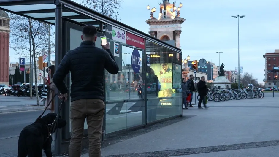 In Barcelona's Plaza España, a man uses a new system that works with a smartphone to help visually impaired people navigate public transport.