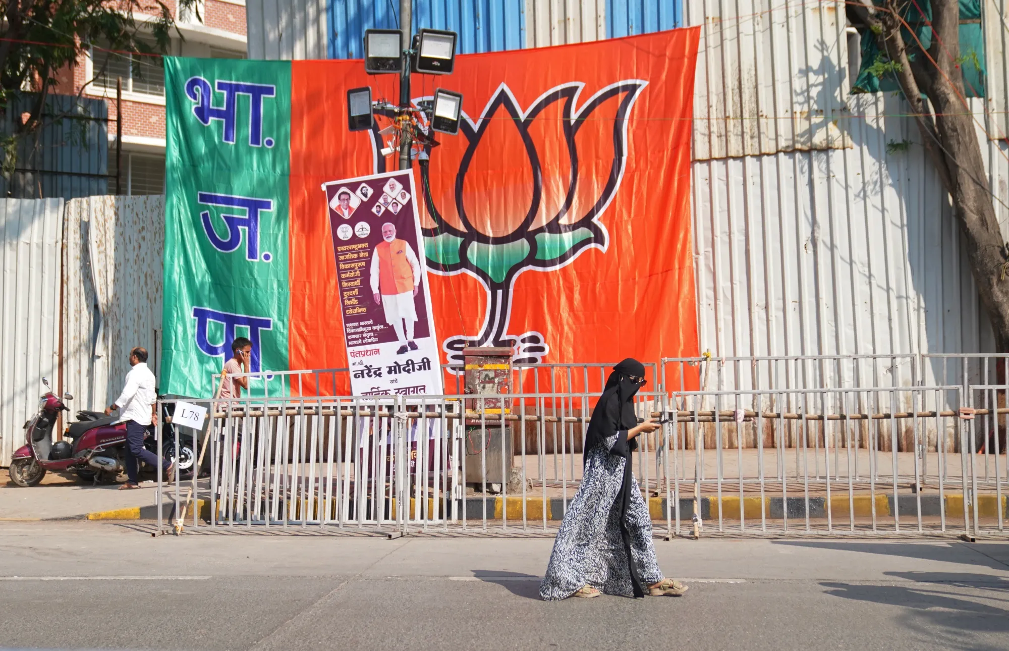 A pedestrian walks past a flag during a campaign rally with Narendra Modi in Mumbai, on May 15.