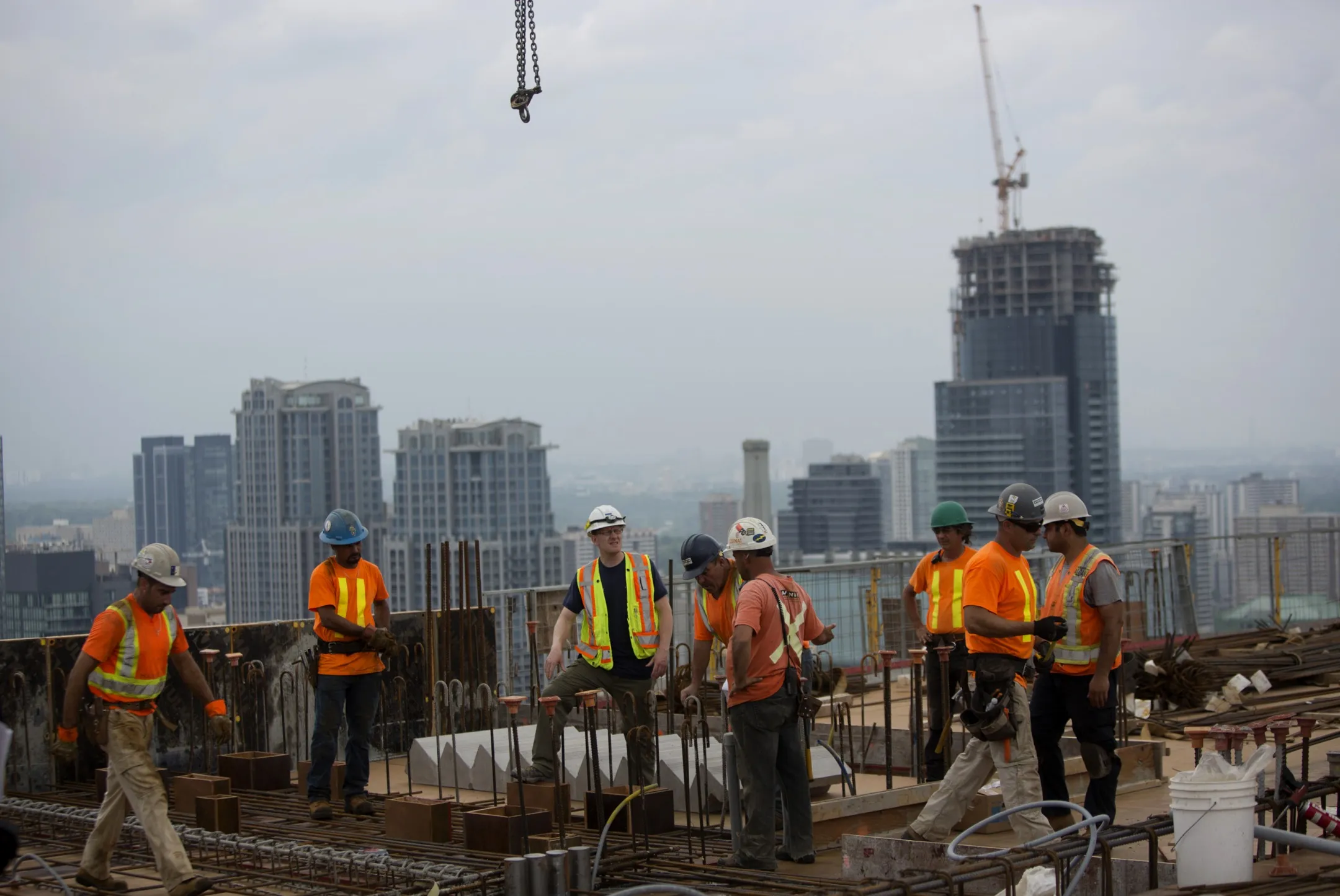 Contractors work on top of a condominium under construction in Toronto, Ontario.
