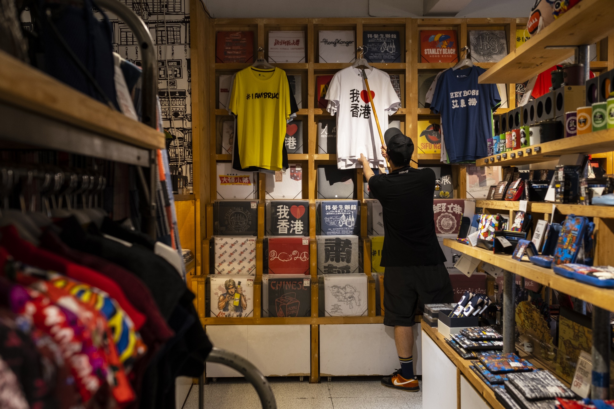 A salesperson hangs an “I Love Hong Kong” T-shirt inside a Goods of Desire store in Hong Kong on July 23.