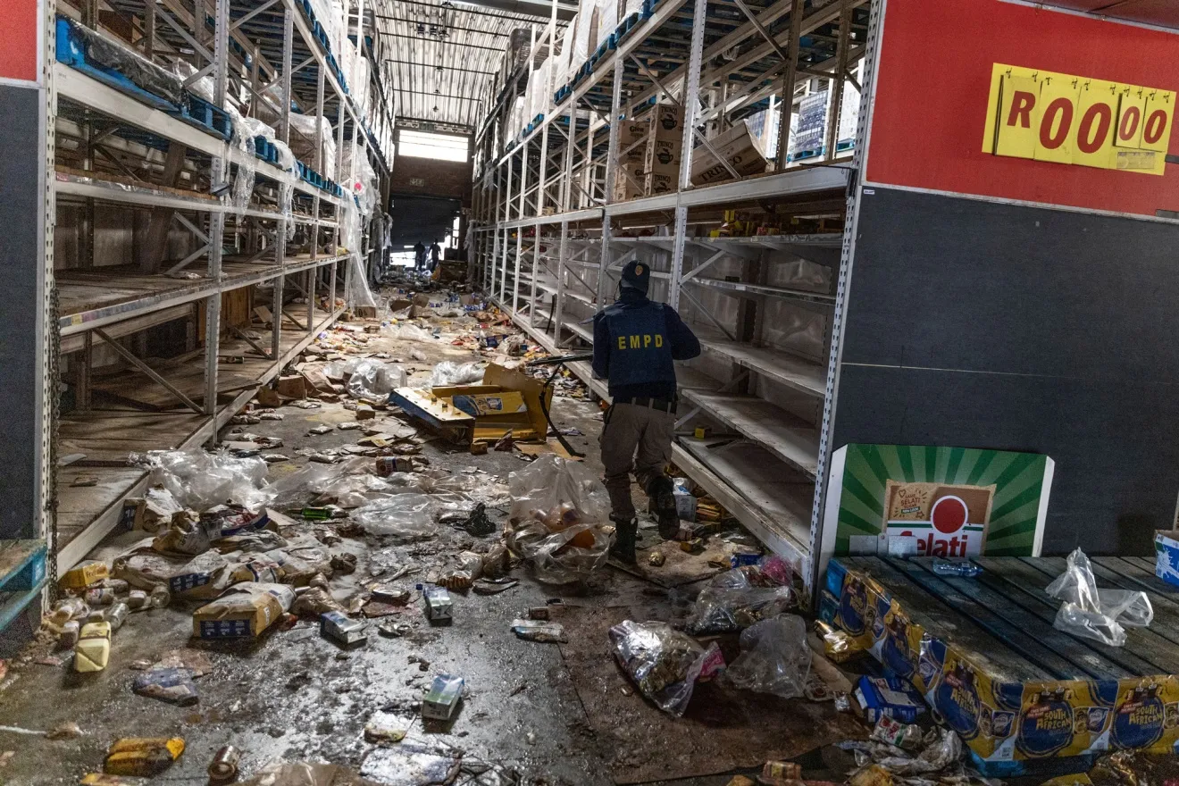 A police officer searches for looters inside a shopping center in Vosloorus, southeast of Johannesburg, in July 2021.