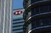 A logo sits on the HSBC Holdings Plc headquarter skyscraper offices .