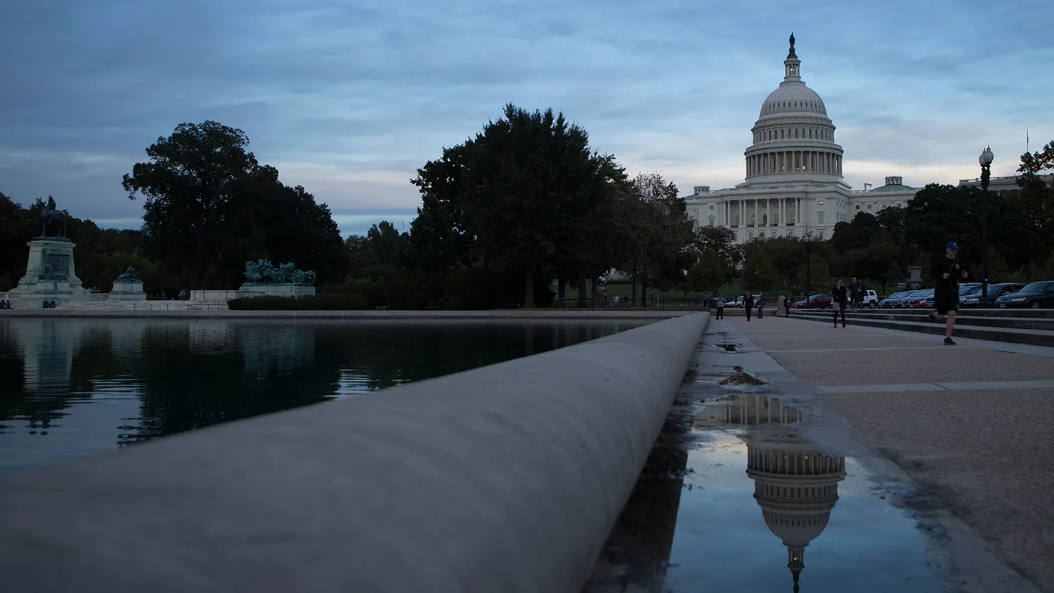 The U.S. Capitol is reflected in a puddle next to the Capitol Reflecting Pool in Washington, D.C., U.S., on Tuesday, Oct. 15, 2013.
