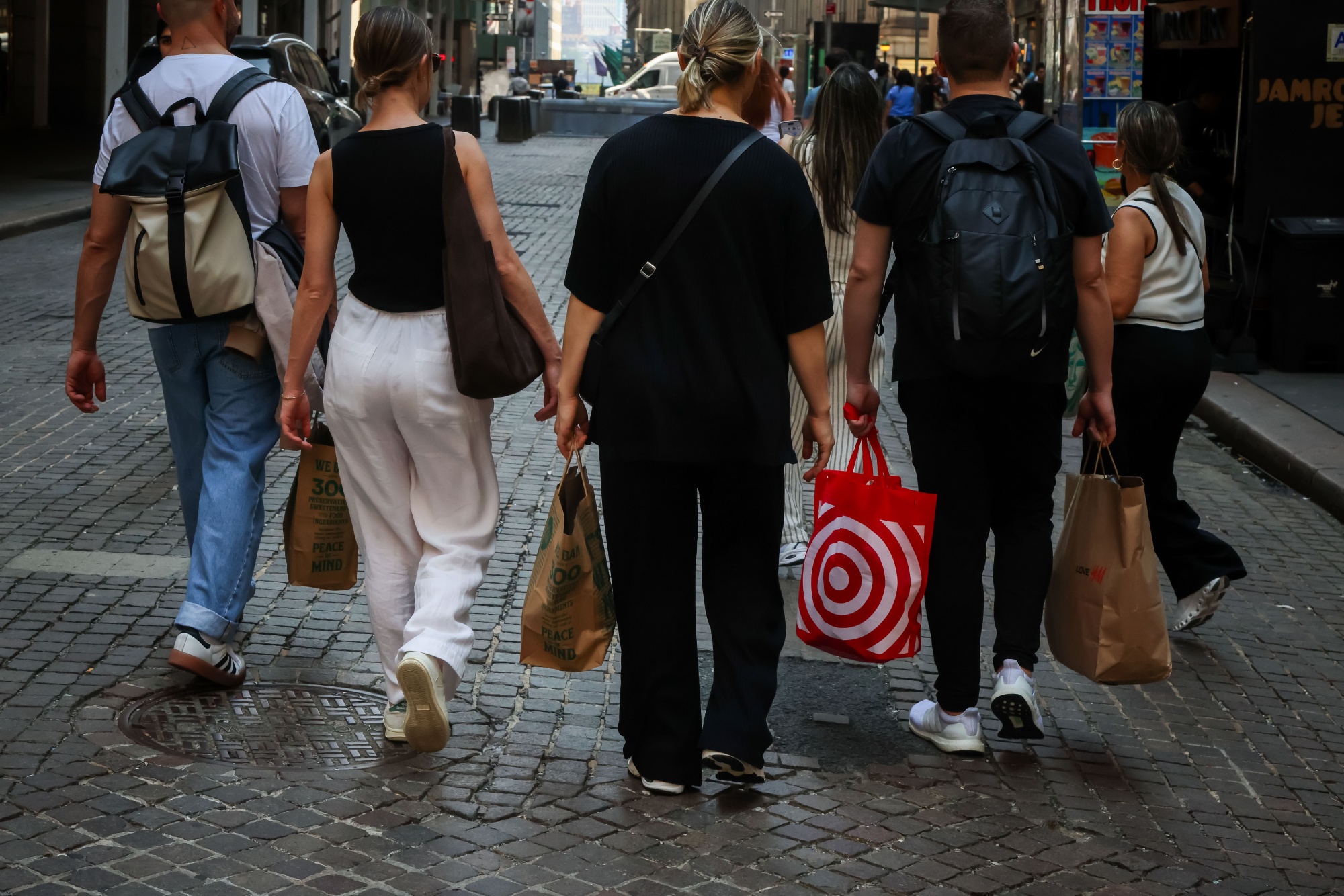 Shoppers carry bags along Wall Street in New York.