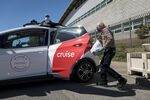 A volunteer loads bags of food into a Cruise self-driving training car in San Francisco. Cruise is majority-owned by GM.