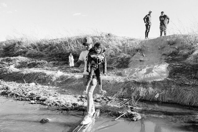 A relative carries Fernanda Tonito across the Rio Grande in Ciudad Juárez, on April 10.