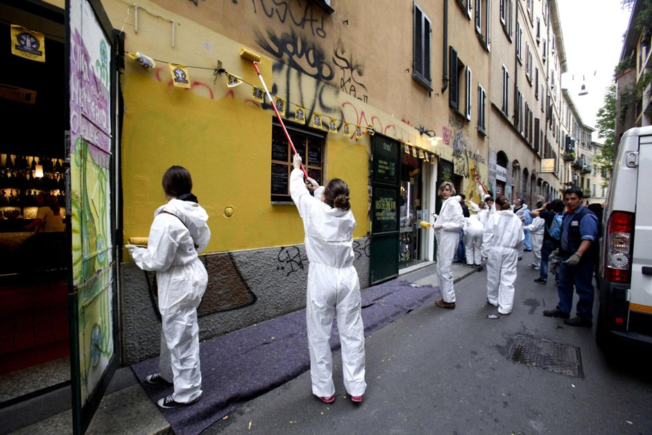 Demonstrators paint a wall covered in graffiti in Milan, Italy, on Sunday, May 3, 2015, during a march to protest violence that left much of downtown trashed on May Day. Hundreds of the marchers removed graffiti and helped repair other damage wreaked by protesters who rampaged through downtown two days earlier against Expo 2015.