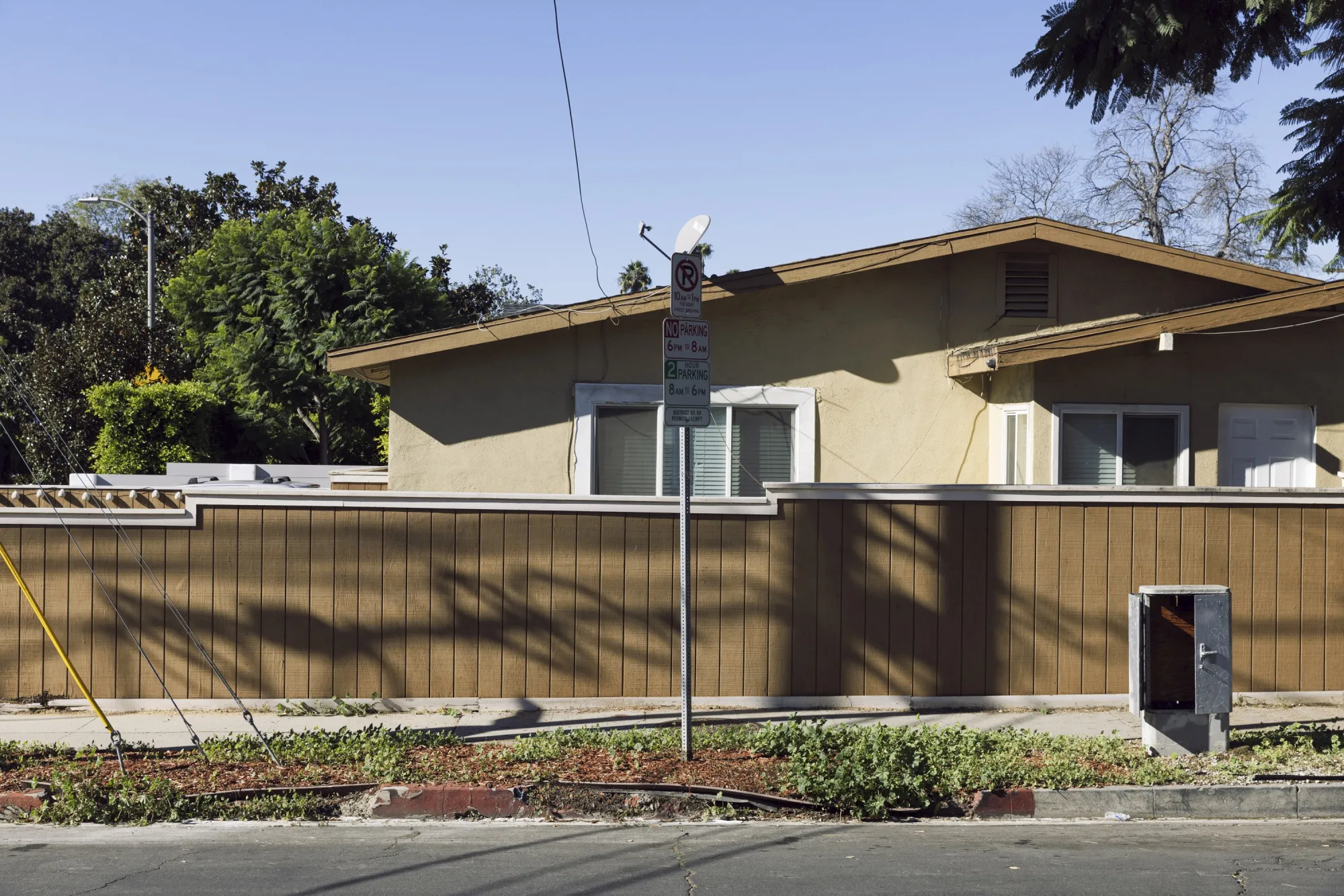 a photo of a house with a beige fence infront of it