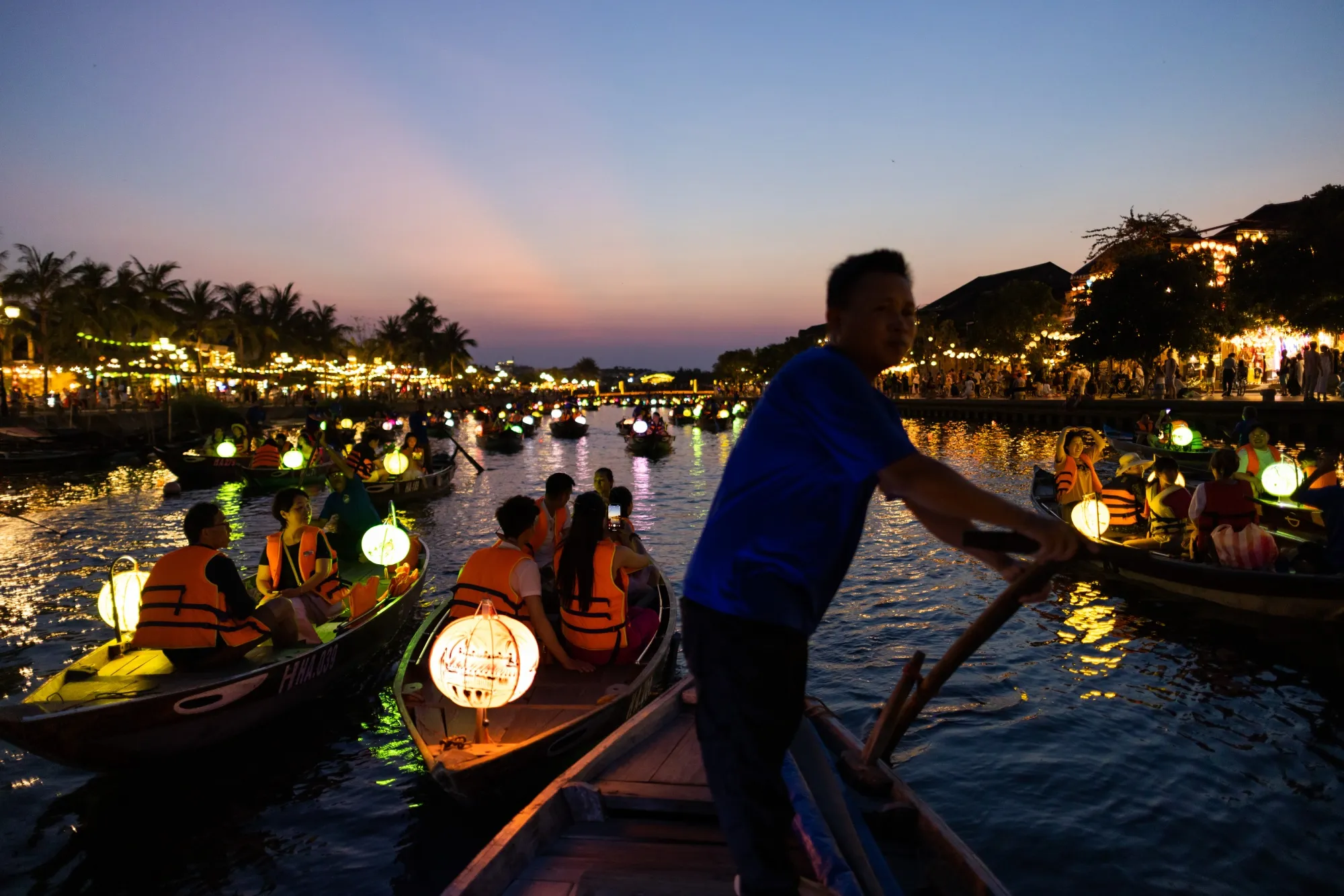 Tourists ride boats along the river in the old town of Hoi An.