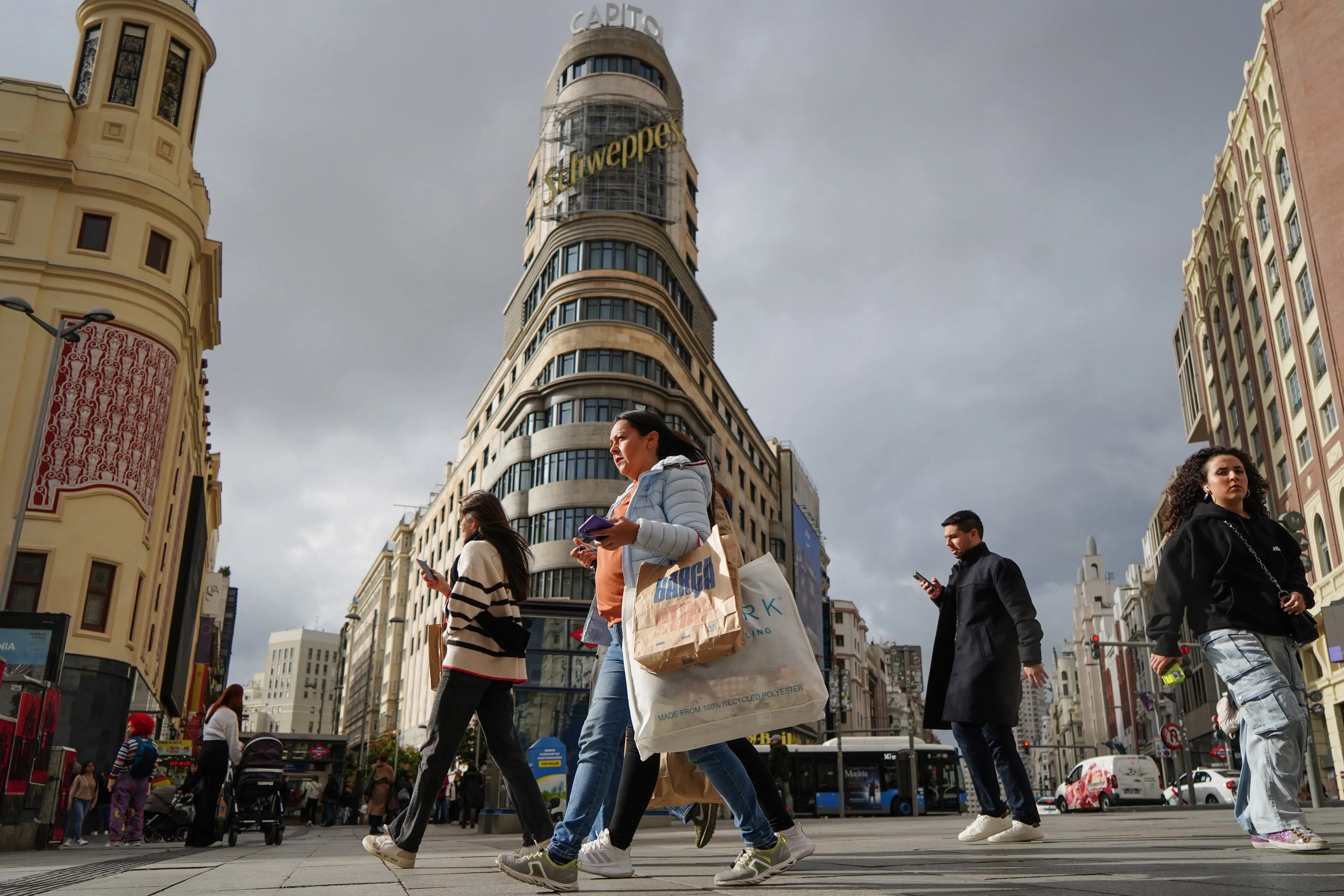 Shoppers cross the Gran Via in central Madrid, Spain.
