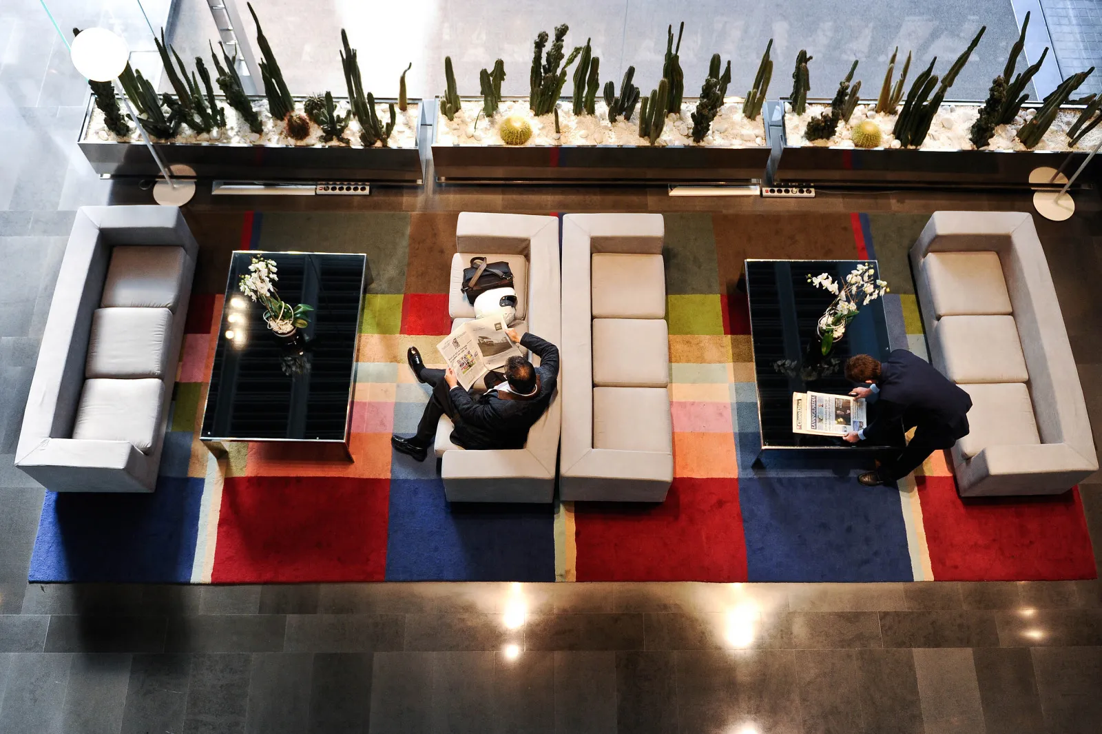 A hotel guest sits and reads a newspaper&nbsp;in the lobby at the NH Constanza hotel, operated by NH Hoteles SA in Barcelona, Spain.