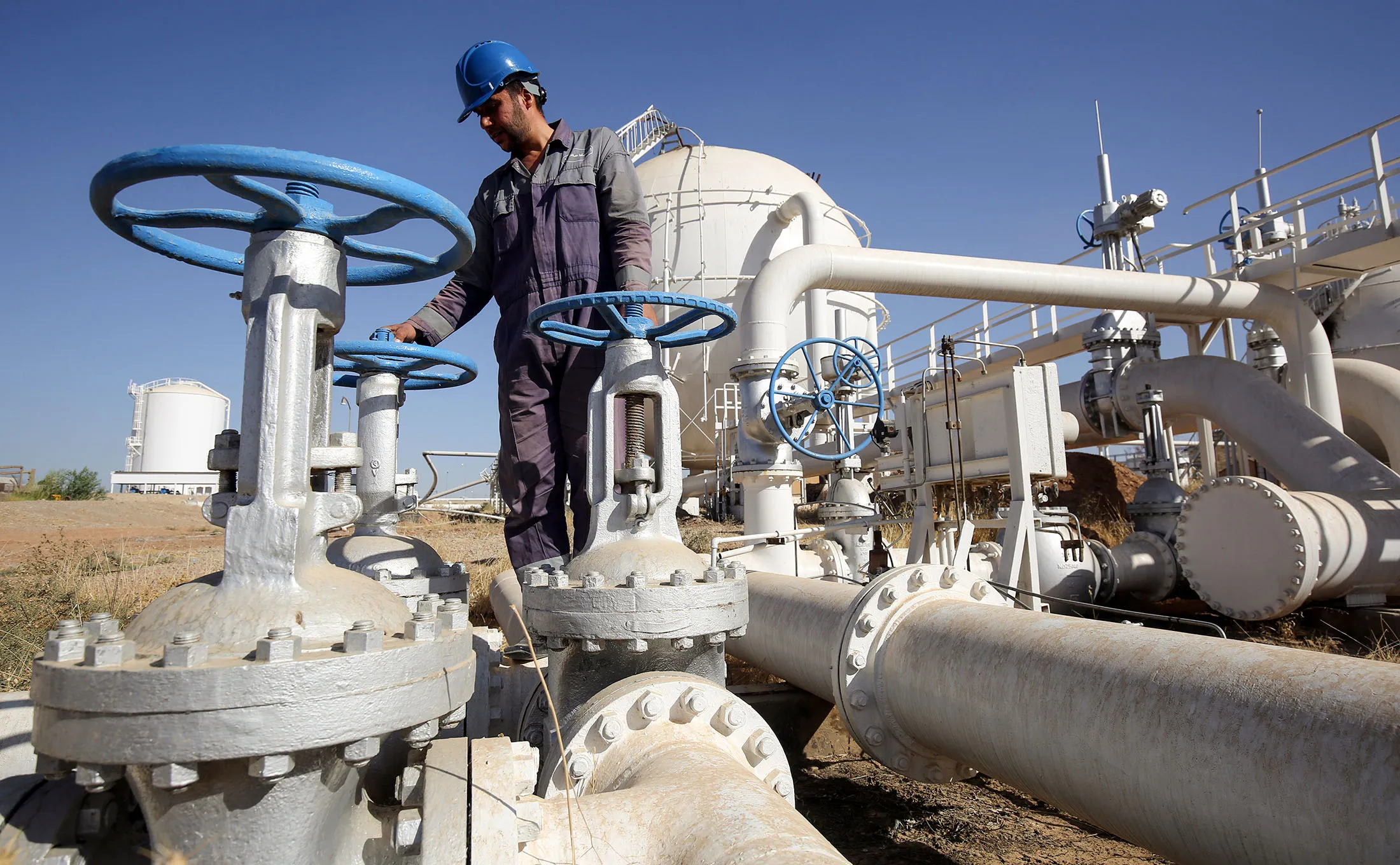 An Iraqi oil employee checks pipelines at the Bai Hassan oil field, west of the multi-ethnic northern Iraqi city of Kirkuk,