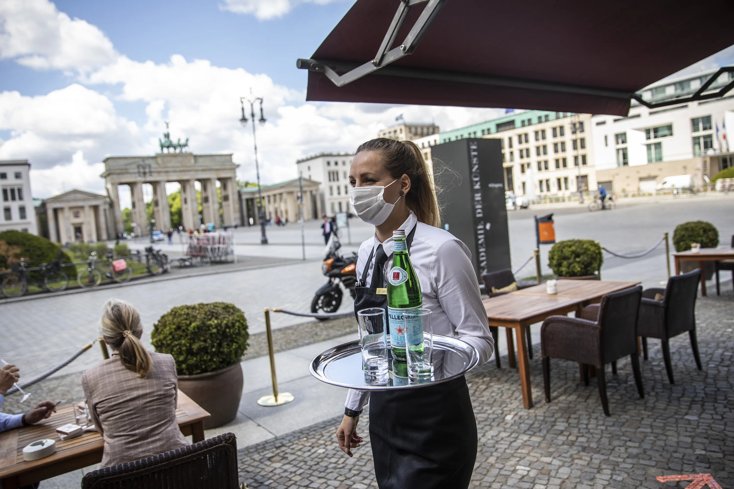 A waitress wearing a face mask works in a restaurant near the Brandenburg Gate in Berlin, on May 26.