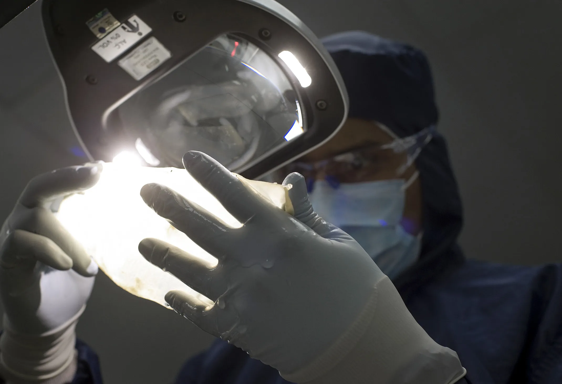 A worker observes pig heart membrane, or pericardium, that will be used in the production of human heart valve replacements at the Medtronic Inc. assembly plant in Tijuana, Mexico, on Oct. 27, 2014.
