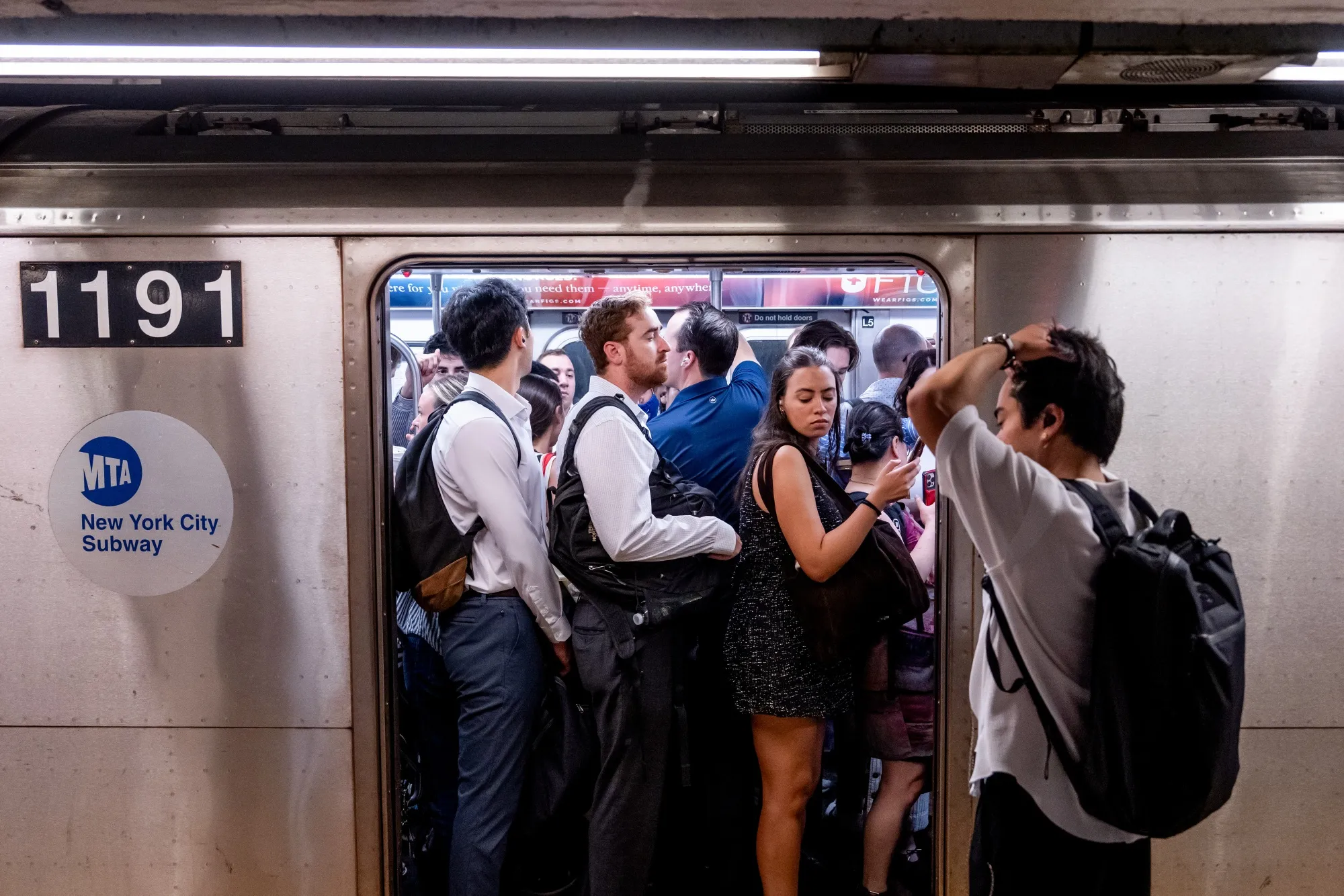 Commuters board a train at a New York City subway station.