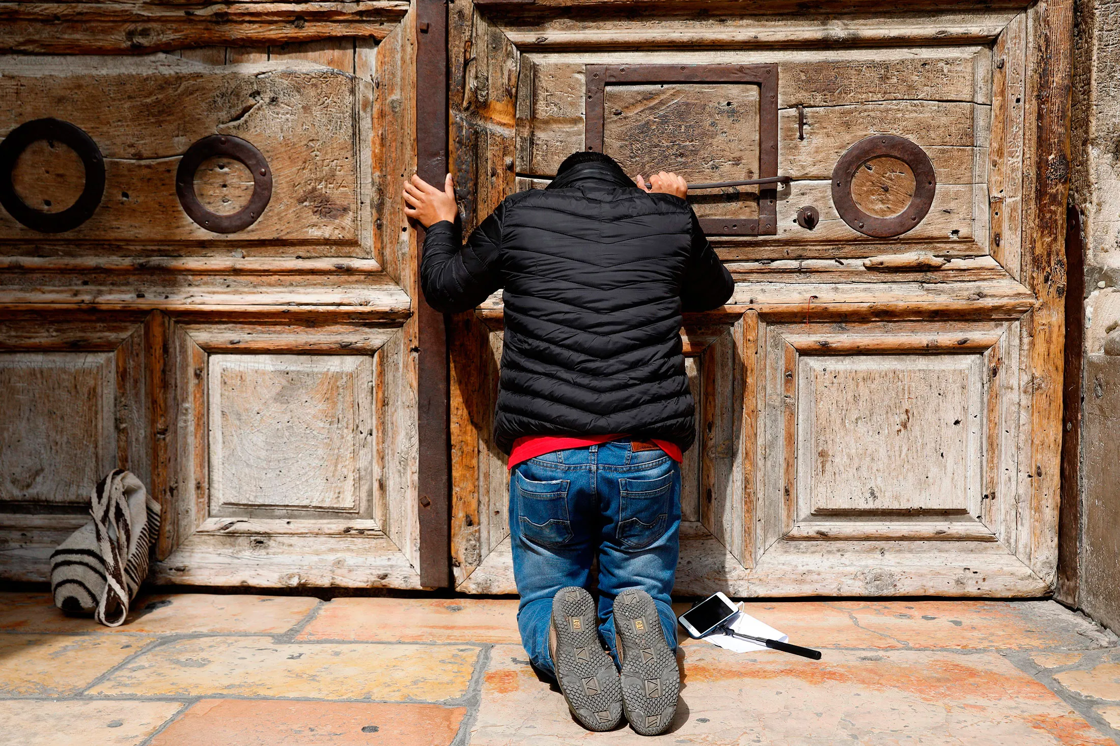 A pilgrim prays outside the closed gate of the Church of the Holy Sepulchre&nbsp;on Feb. 25.