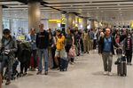 Travelers wait in a long queue to pass through the security check at Heathrow Airport, London, on June 1. 