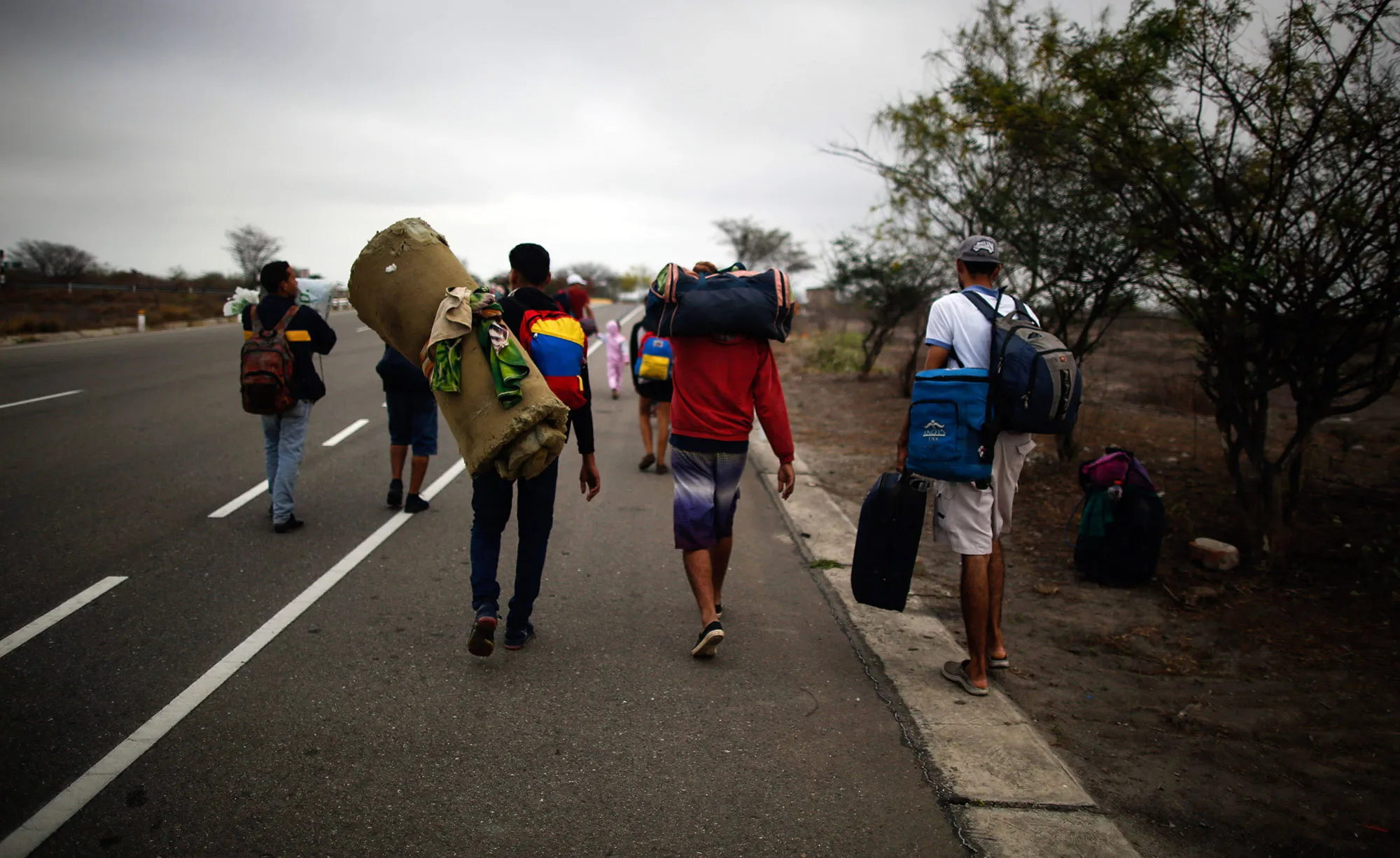 Venezuelan migrants walk along a road in Tumbes, Peru, on Nov. 1, 2018.