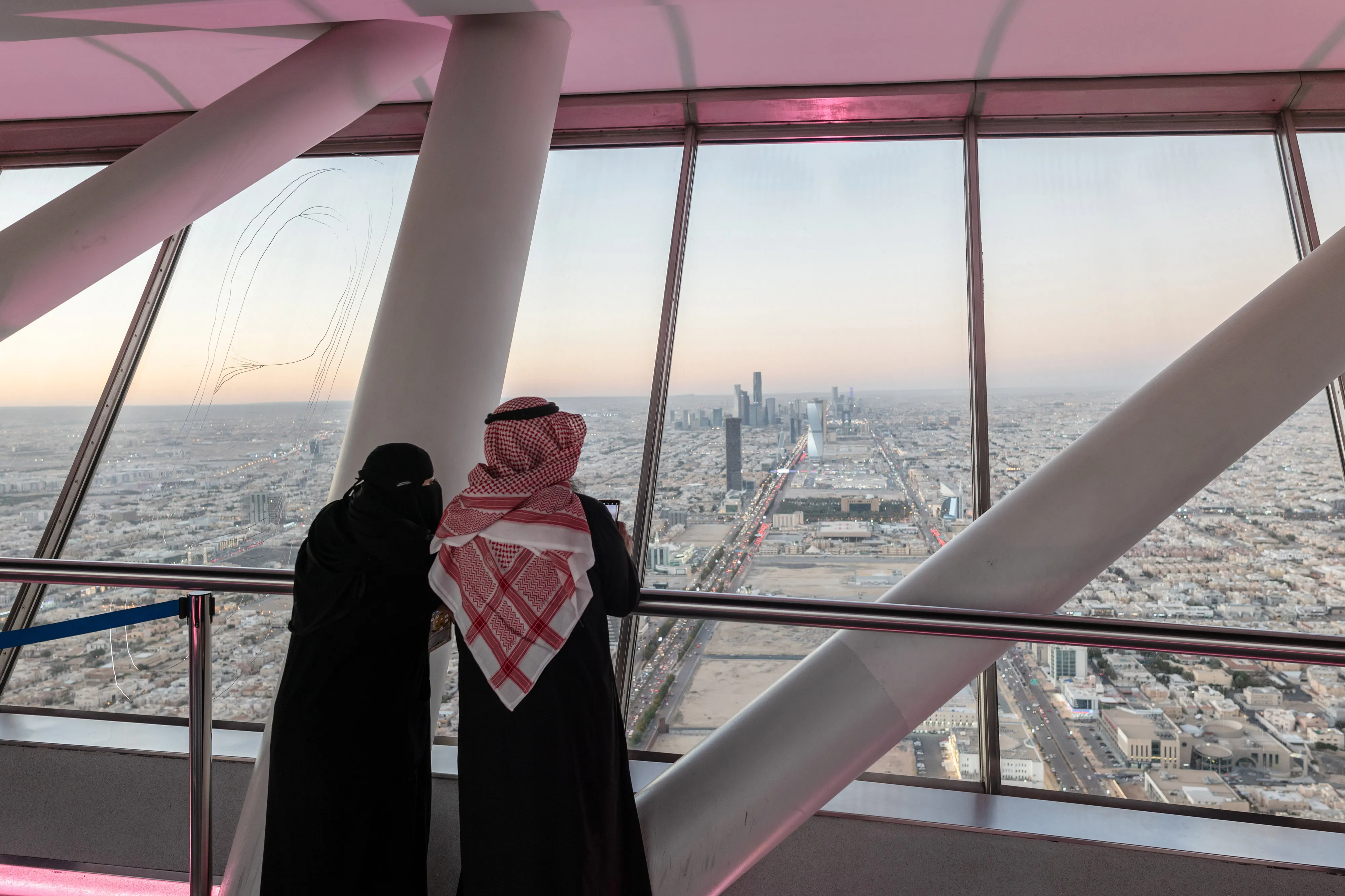 Visitors looks out towards the city skyline from the skybridge of the Kingdom Center, in Riyadh, Saudi Arabia.