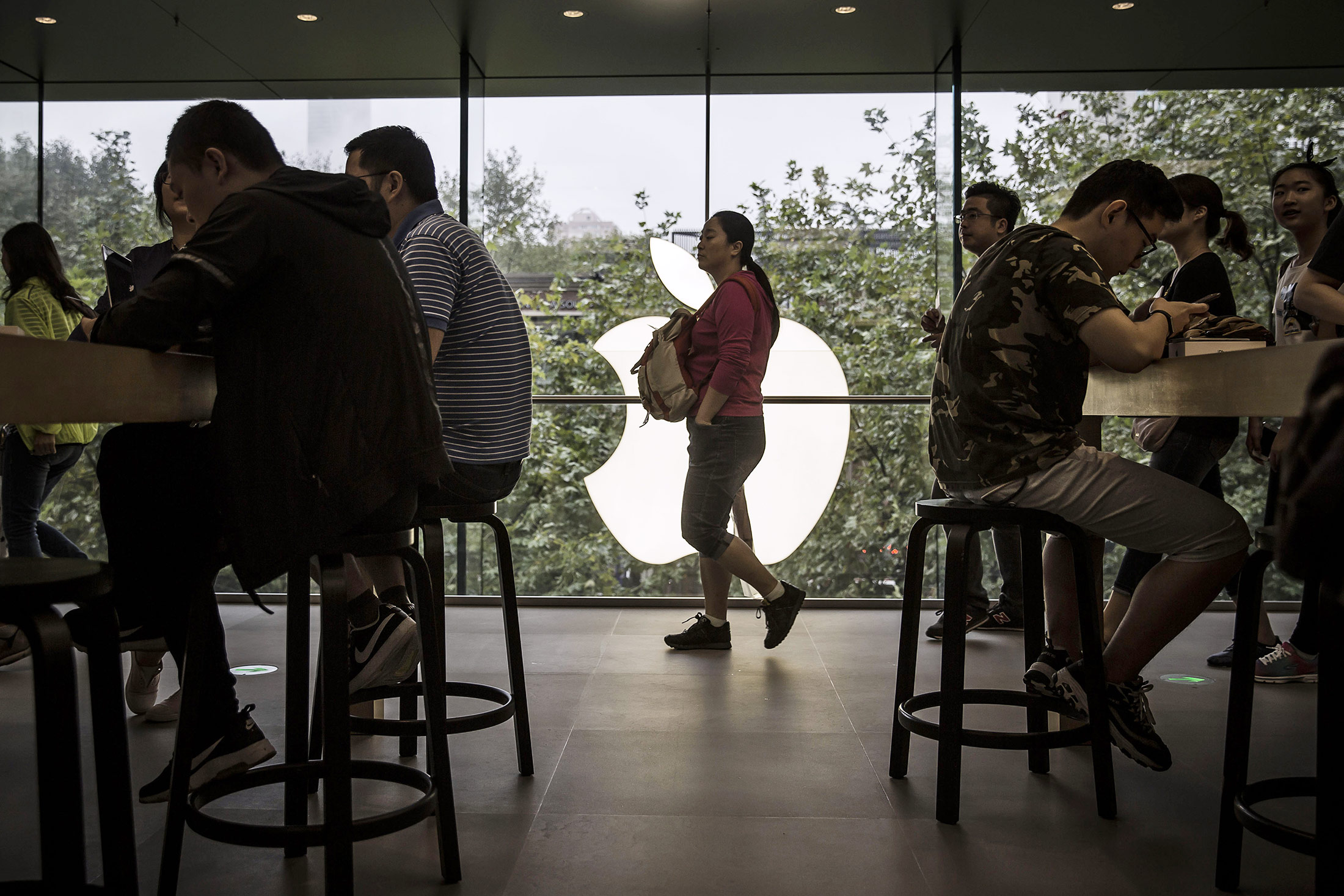 Customers browse in the Apple Inc. Store inside the IAPM shopping mall in Shanghai.
