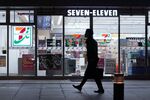 A pedestrian is silhouetted while walking past a 7-Eleven convenience store, operated by Seven & i Holdings Co., at night in Tokyo, Japan, on Friday, Jan. 10, 2020.