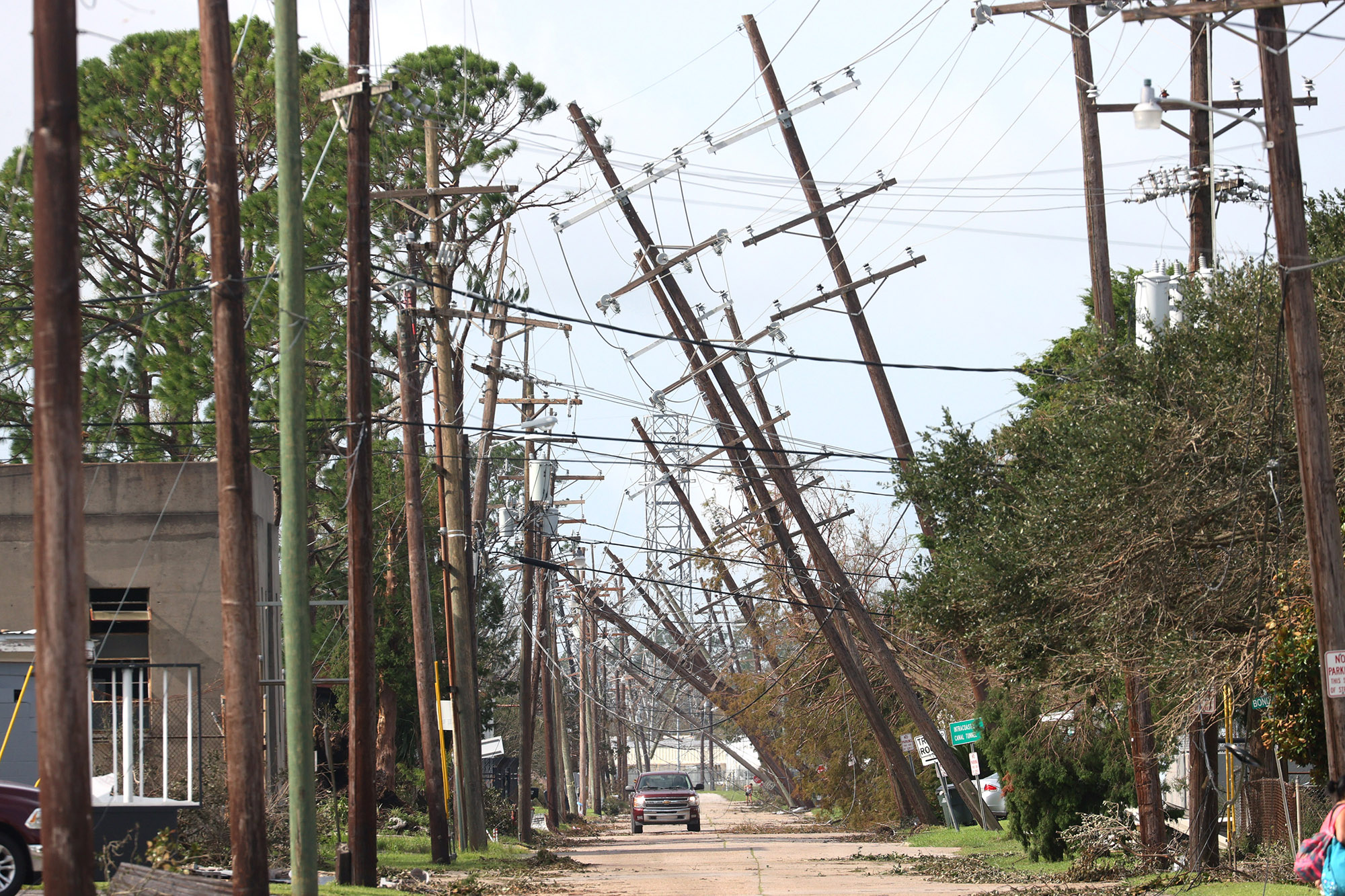 Utility poles lean over a street following Hurricane Ida in Houma, Louisiana.
