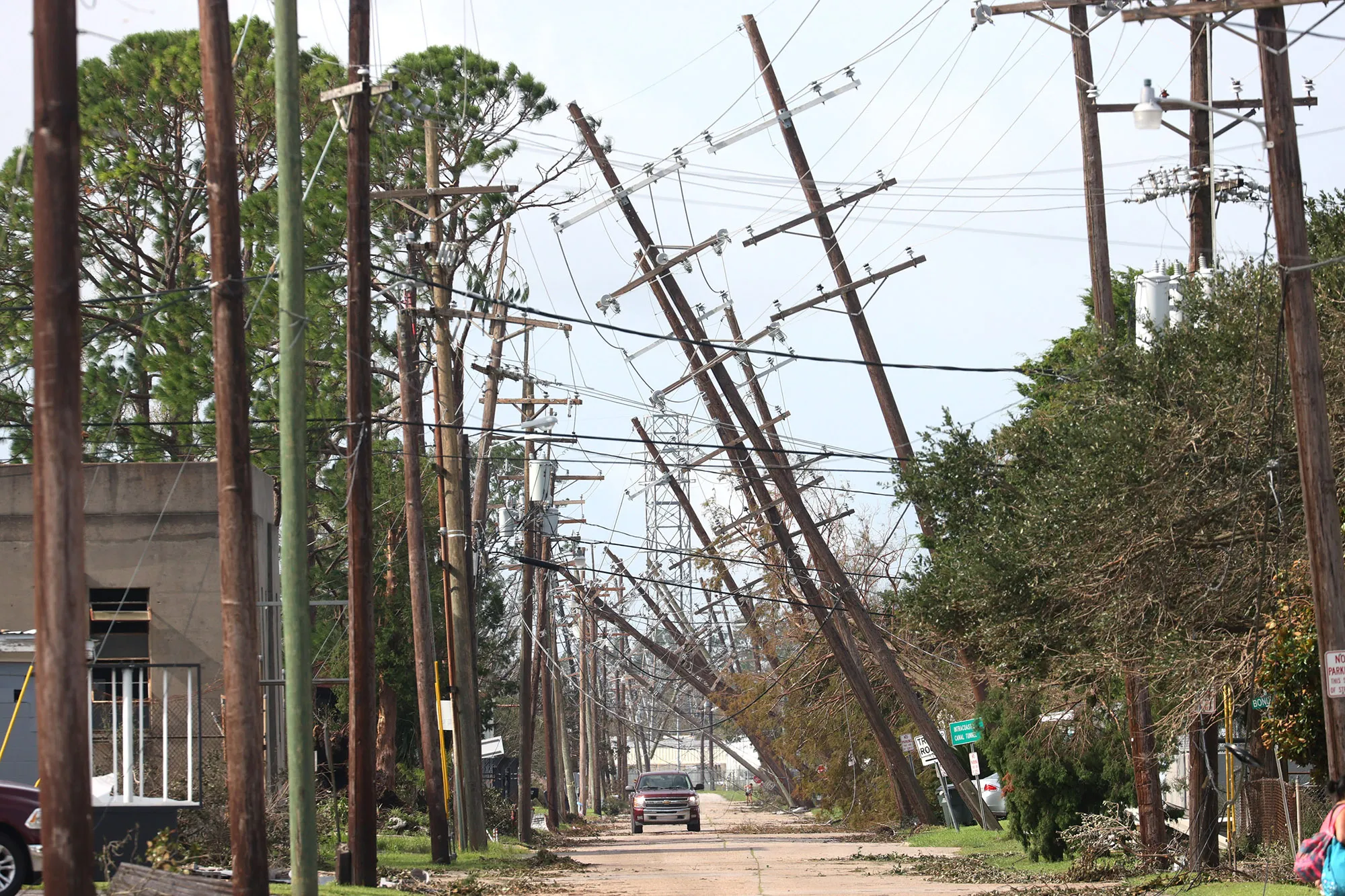 Utility poles lean over a street following Hurricane Ida in Houma, Louisiana.