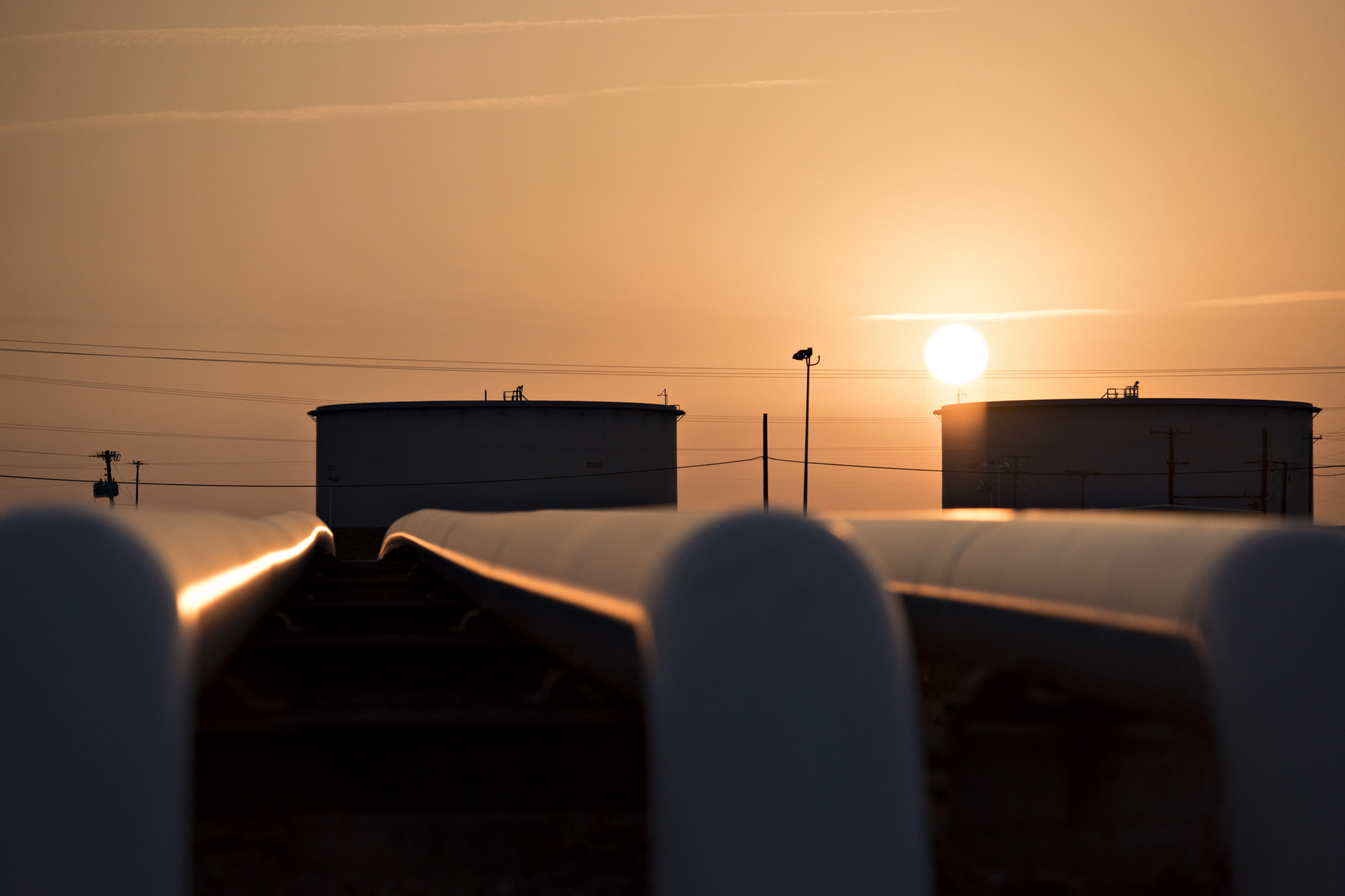 The sun rises beyond oil storage tanks at the Enbridge Inc. Cushing storage terminal in Cushing, Oklahoma, U.S., on Wednesday, March 25, 2015. The fastest oil-inventory growth on record at the main U.S. hub may be about to end, easing concern that storage limits will be strained.