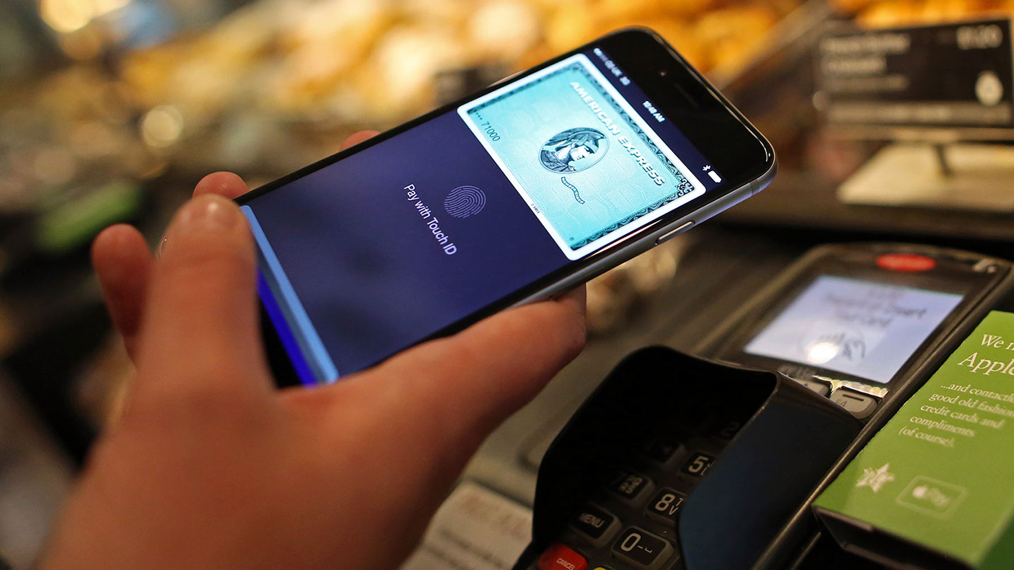 A customer using Apple Pay, via an American Express account, on an Apple iPhone spends at a Pret A Manger Ltd store in London, U.K., on Tuesday, July 14, 2015. Apple Inc. is making the U.K. the first market outside the U.S. for its digital-wallet system as the company fights for a place in the electronic-payments industry.
