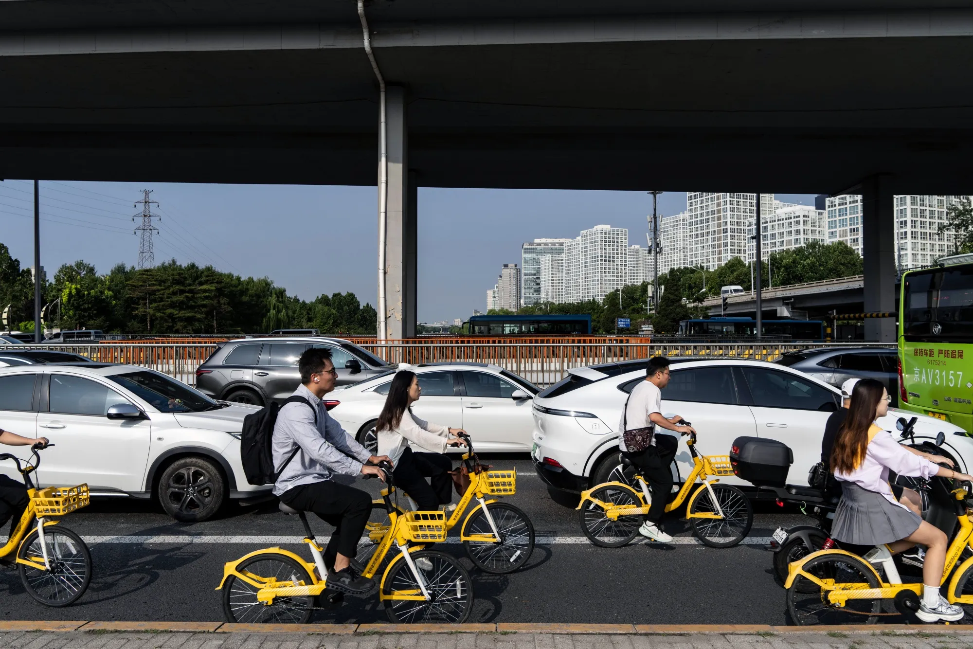 Cyclists and vehicles travel along a road in Beijing on Sept. 2.