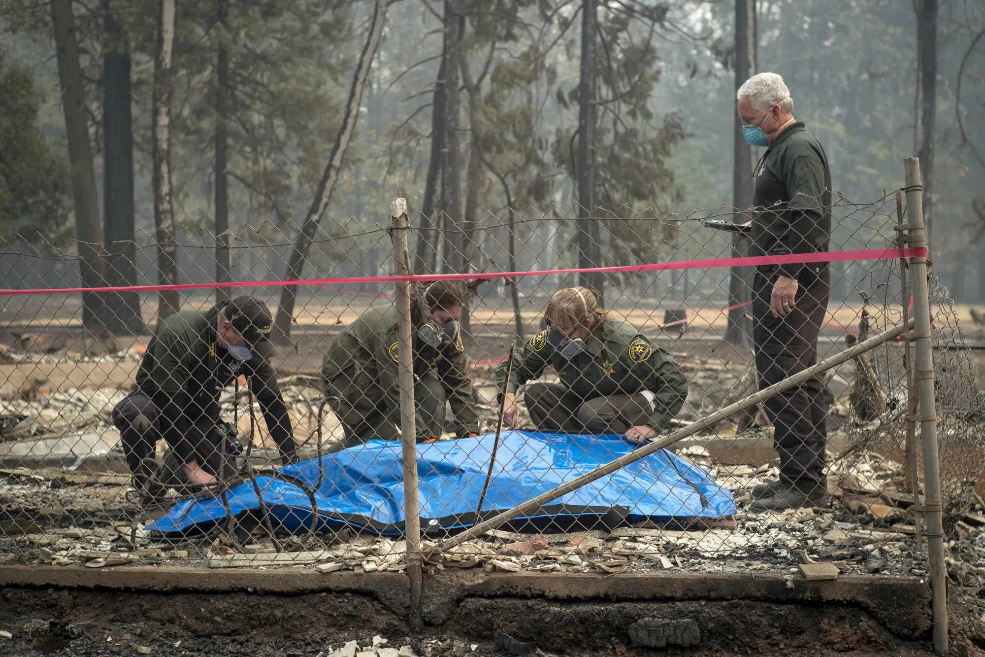Butte County and Fresno County Sheriff officers prepare to remove the remains of a victim of the Camp Fire in Magalia, California,&nbsp;on&nbsp;Nov. 15.&nbsp;