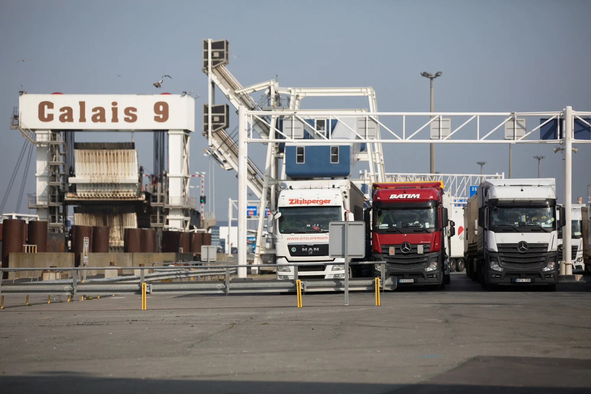 Freight trucks sit parked in departure lanes ahead of boarding a cross-Channel ferry from the Port of Calais.