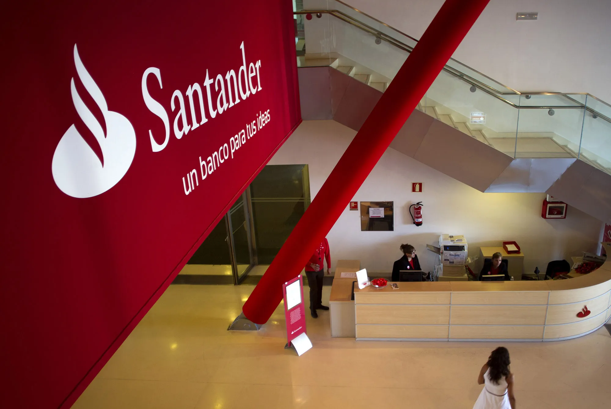 A visitor passes a reception desk inside the headquarters of Banco Santander in Madrid.
