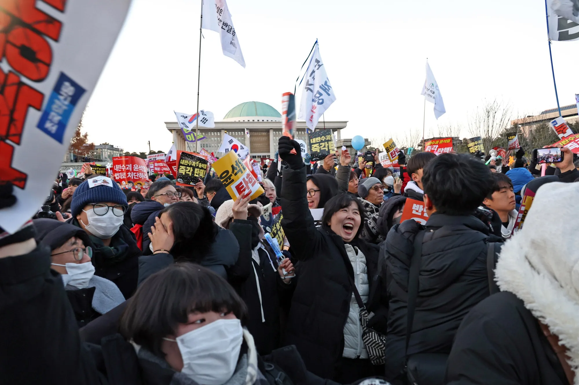 Demonstrators react after lawmakers passed a motion to impeach South Korean President Yoon Suk Yeol in Seoul.