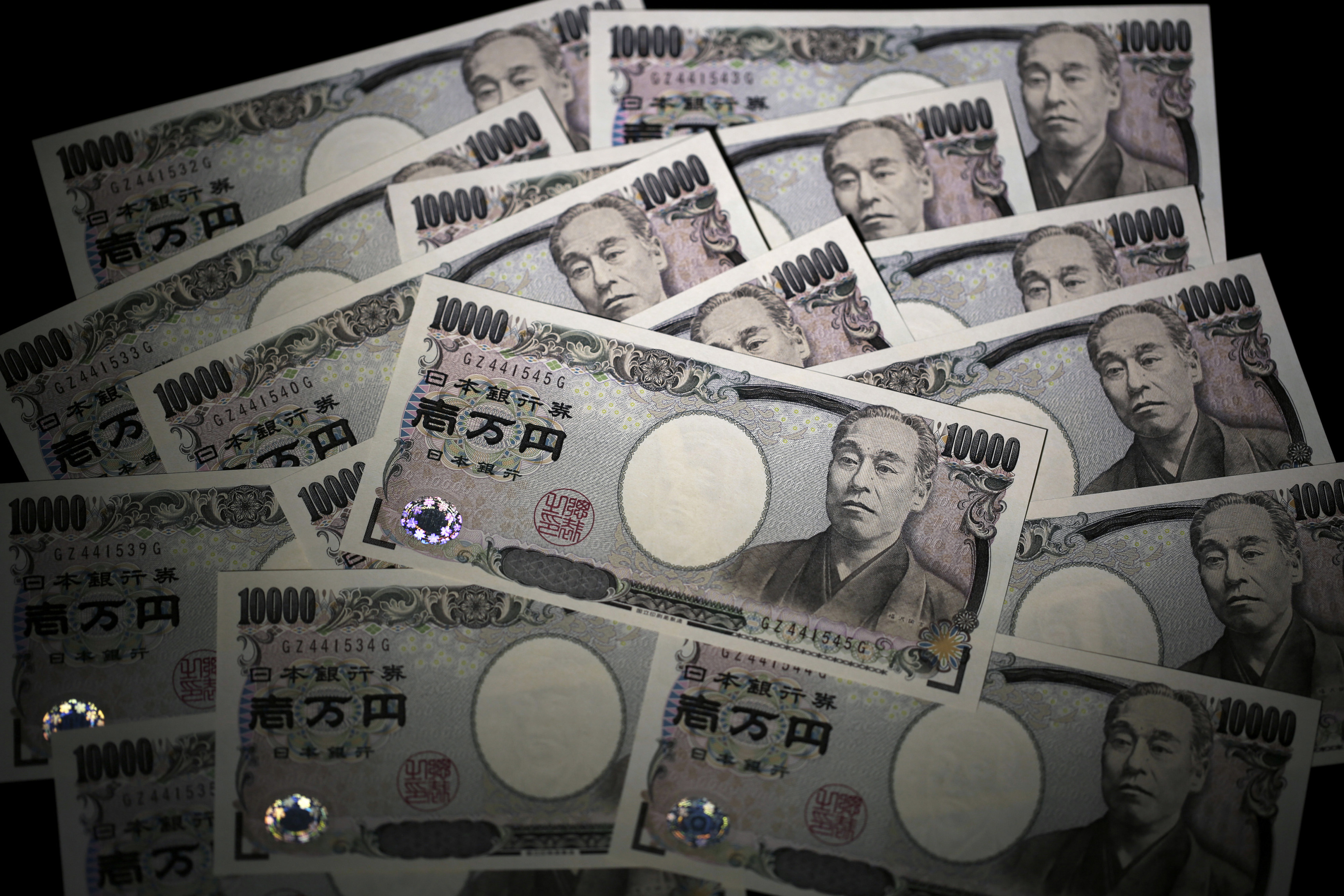 Japanese 10,000 yen banknotes are arranged for a photograph in Tokyo, Japan, on Wednesday, July 22, 2015.  The yen slipped 0.1 percent to 124.03 per dollar after better-than-expected data on U.S. housing and a continuing commodity rout boosted the greenback.