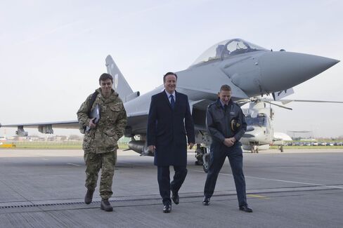 British Prime Minister David Cameron walks past an RAF Eurofighter Typhoon fighter jet during his visit to Royal Air Force station RAF Northolt.