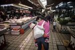 A mother carrying her child at a market in Huizhou, Guangdong province, China.