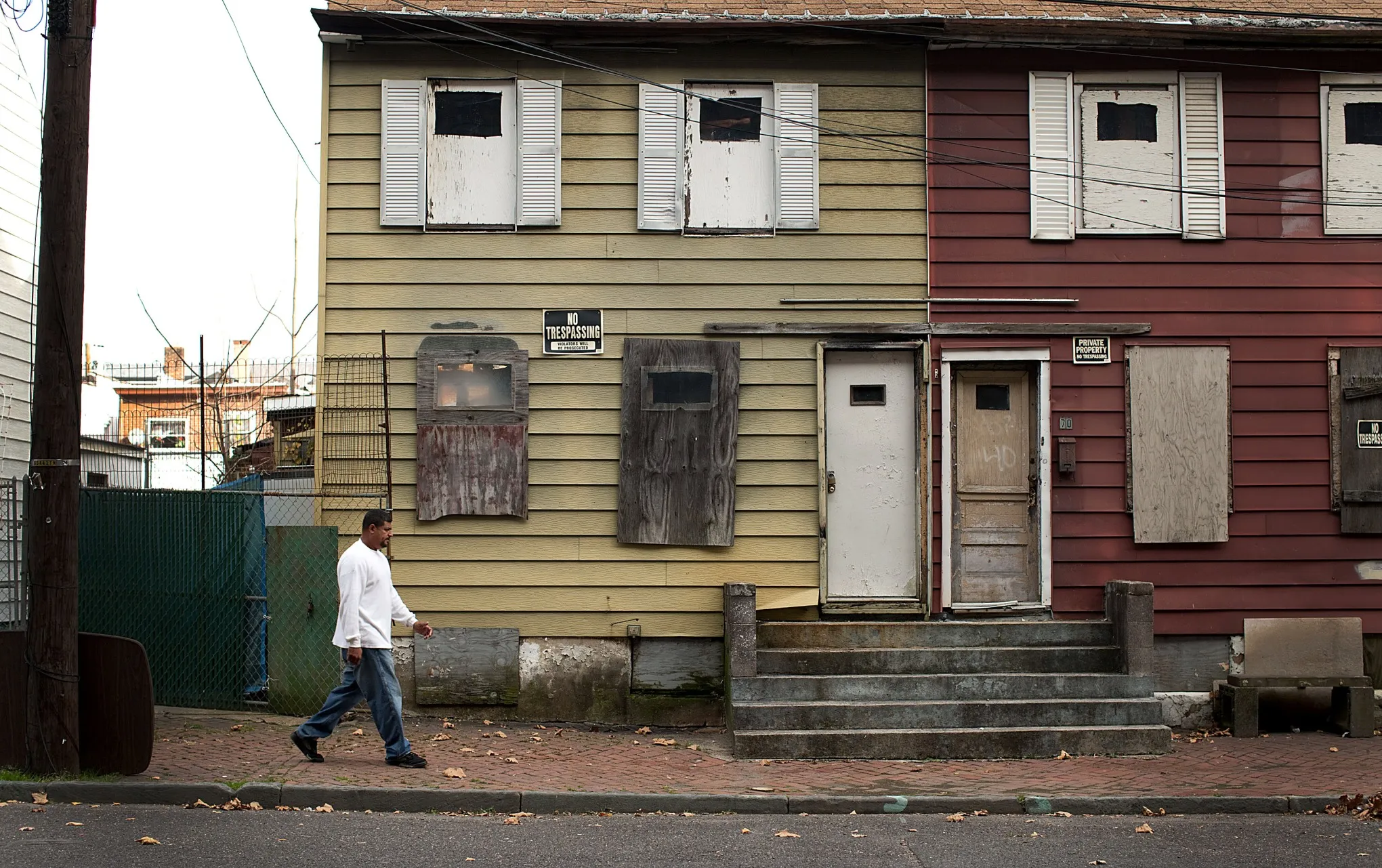 A pedestrian walks past a boarded up residence in Trenton, New Jersey.