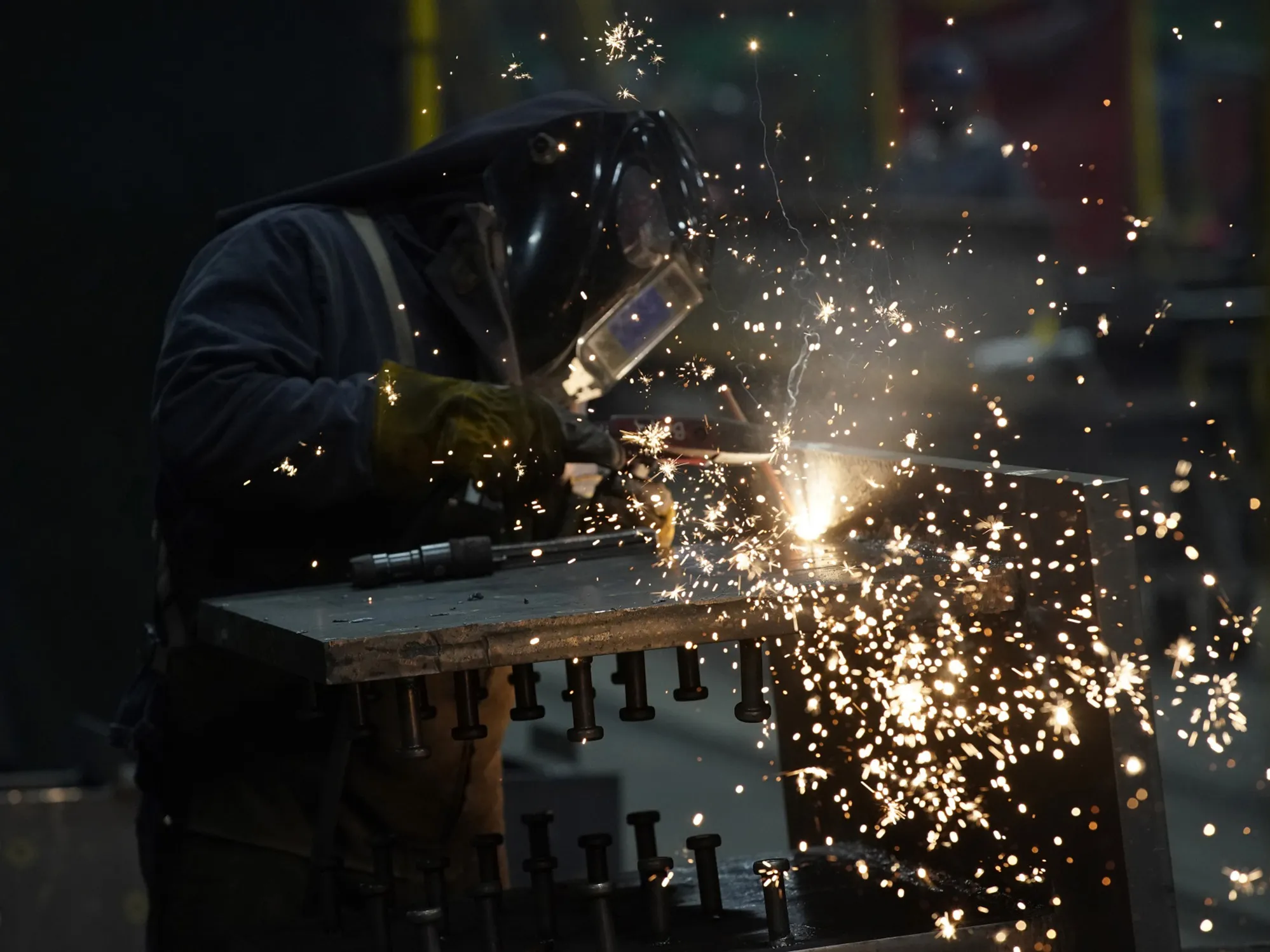 A worker welds a structural beam during production at a steel facility in West Jordan, Utah.