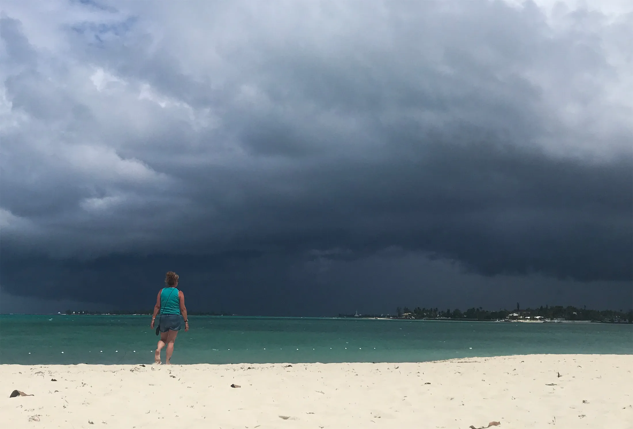 A woman walks on the beach as a storm approaches in Nassau, Bahamas&nbsp;on Sept. 12.