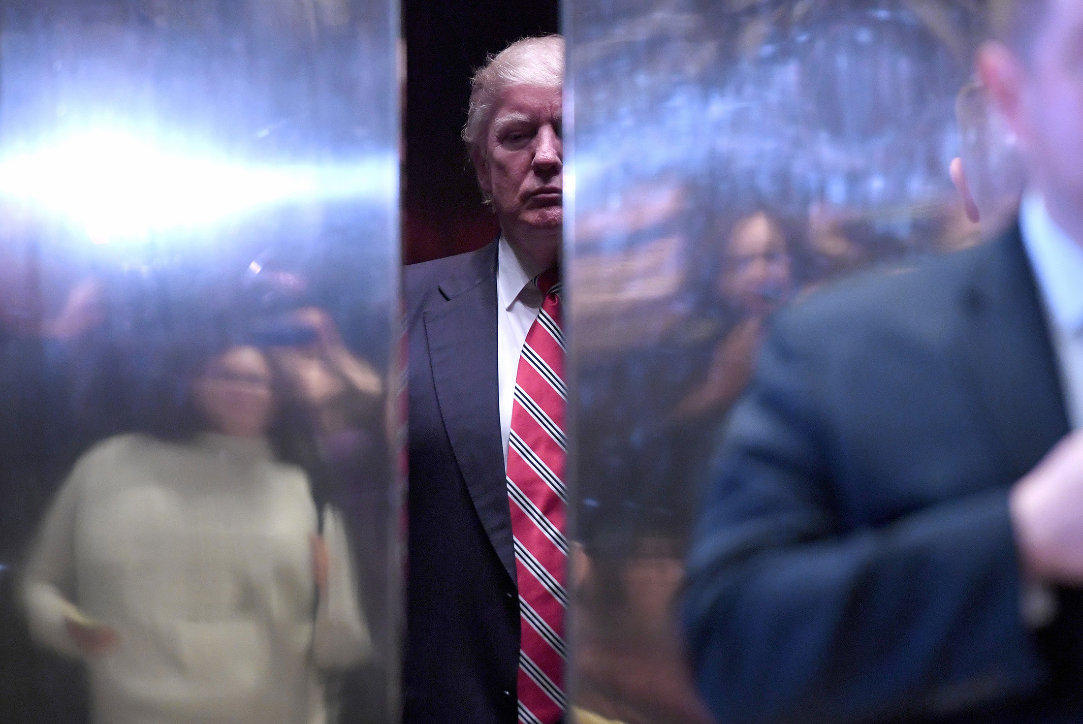 Donald Trump, center, waits in an elevator in the lobby of Trump Tower in New York, on Jan. 16, 2017.
