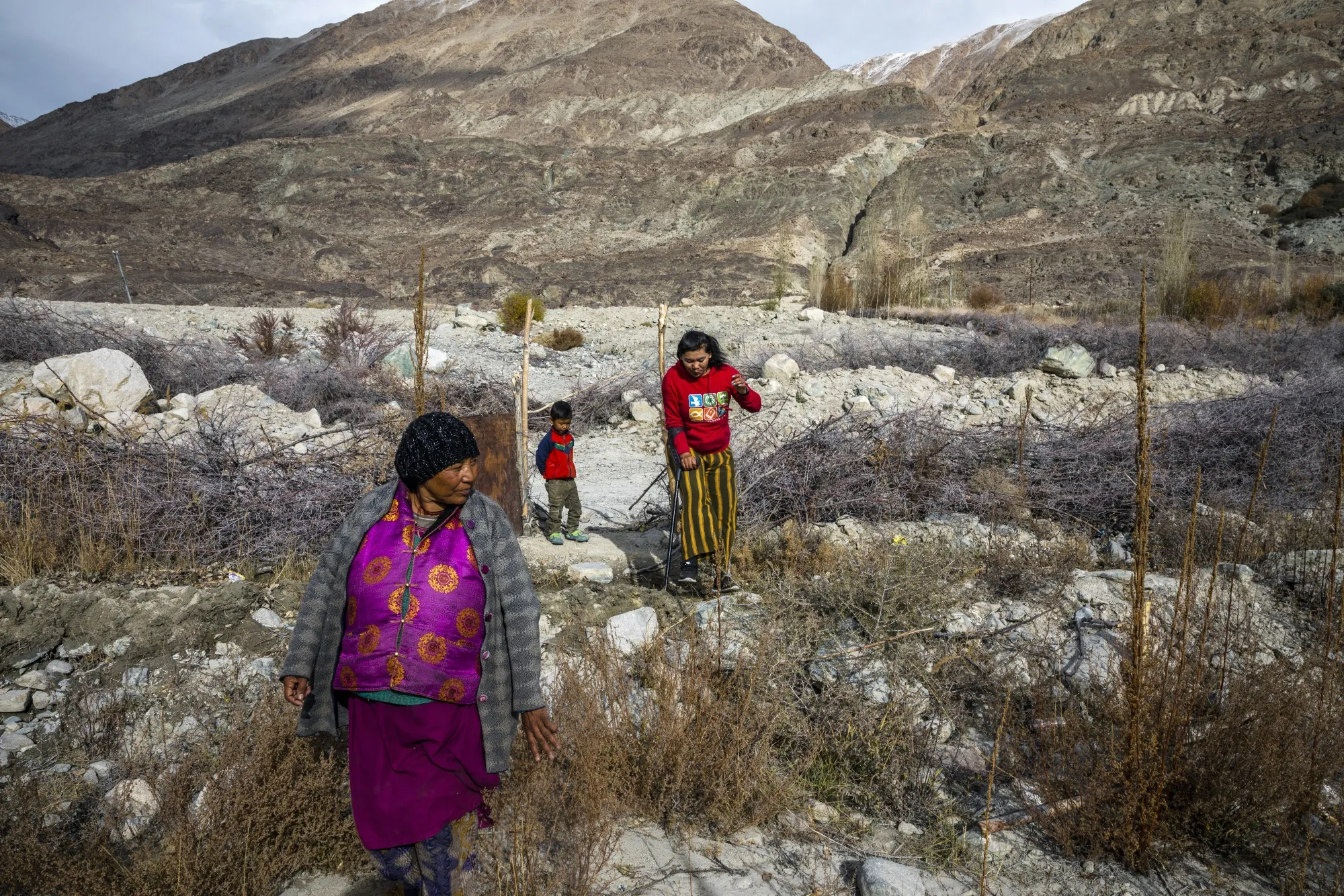 A family show the land where their house previously stood before it was washed away by a cloudburst at Youlkham village in Nubra, Ladakh&nbsp; in India in 2019.