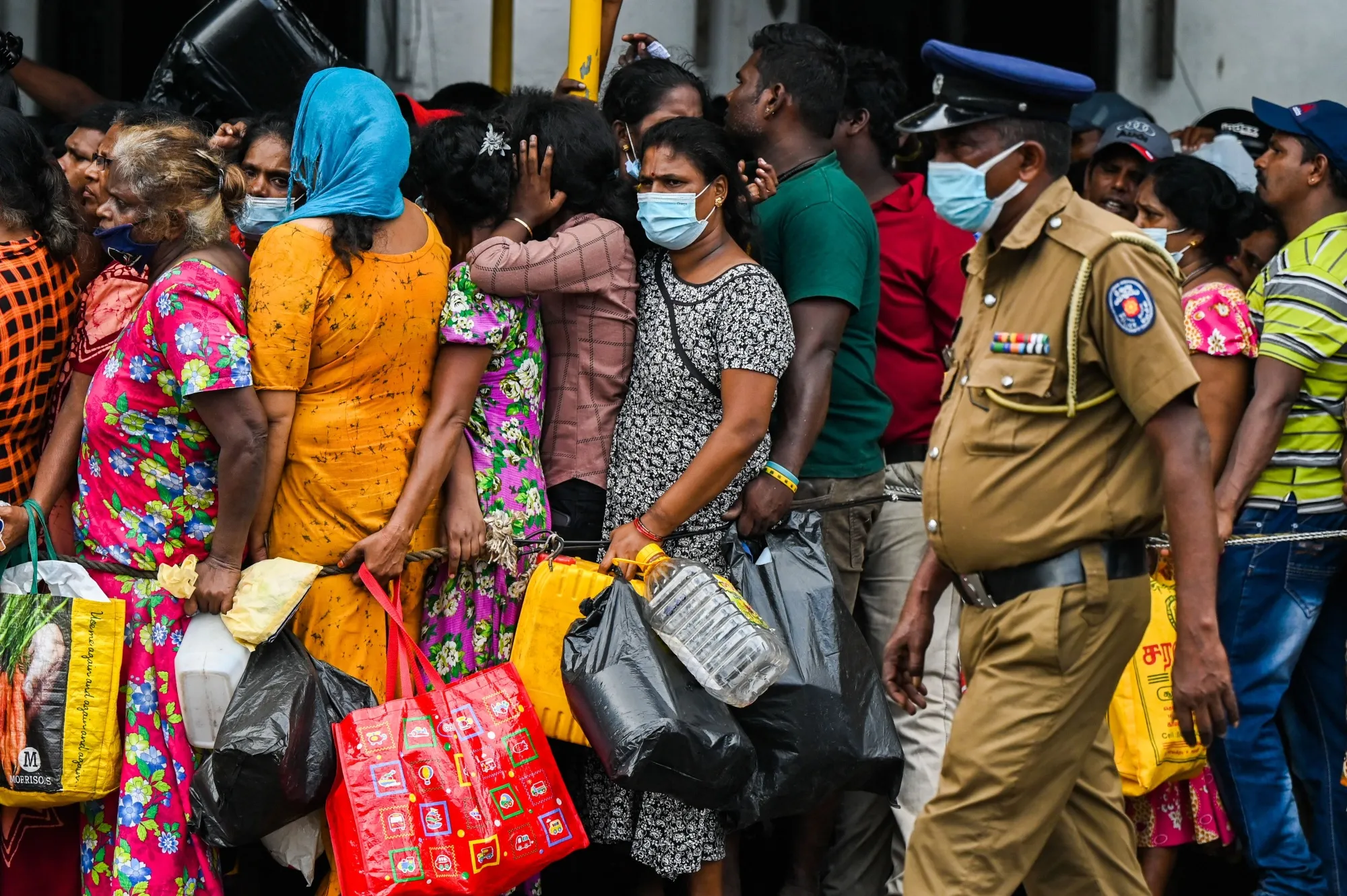 People queue up to buy kerosene for domestic use at a supply station in Colombo, on May 26.