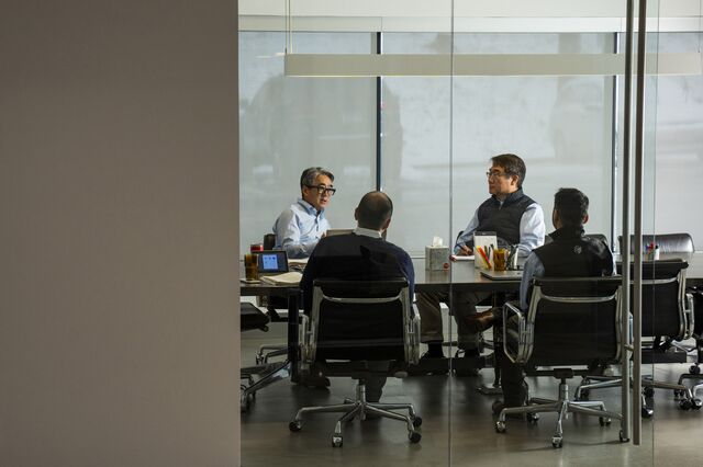 Fermat Capital Management co-founder John Seo in a meeting with co-workers in a conference room at the company office.