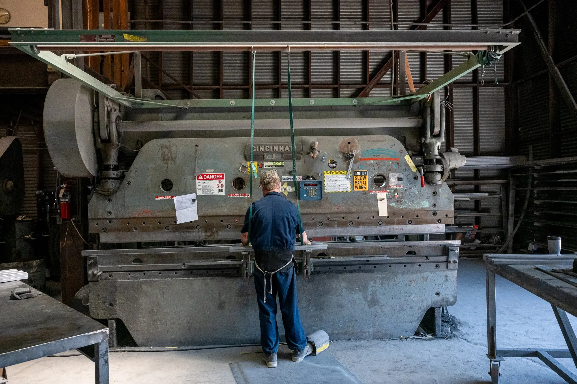 A worker uses a machine to bend sheet metal at a manufacturing facility in Sacramento, California.