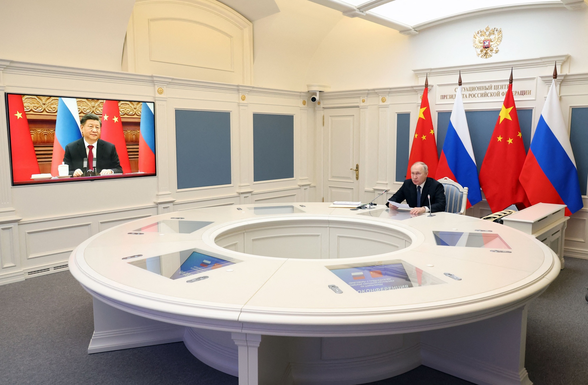 Vladimir Putin, right, speaks with Xi Jinping via video link on Dec. 30.