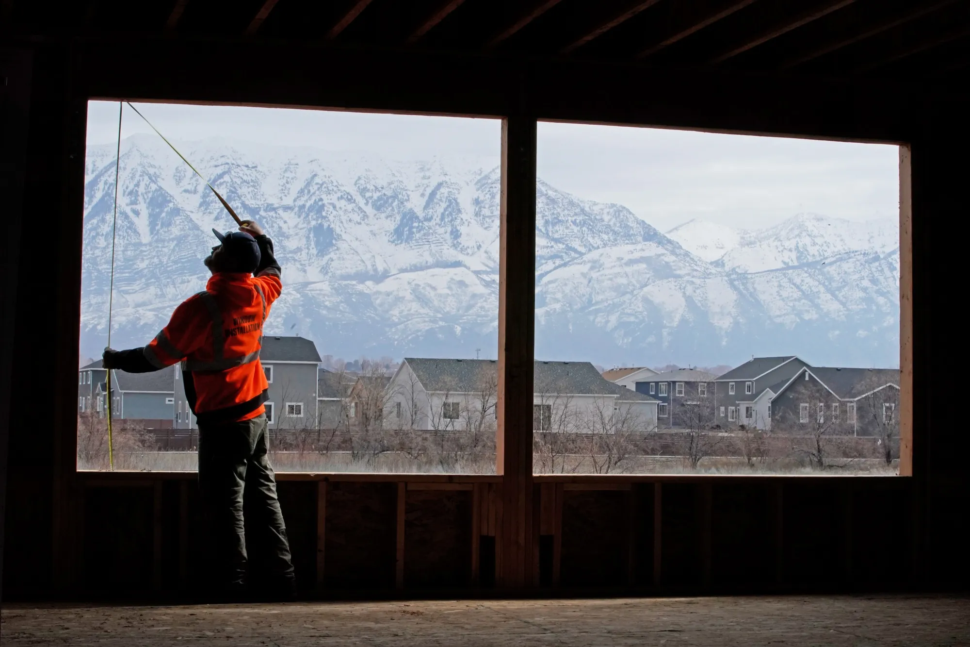 A worker measures a window opening at a home under construction in Vineyard, Utah.