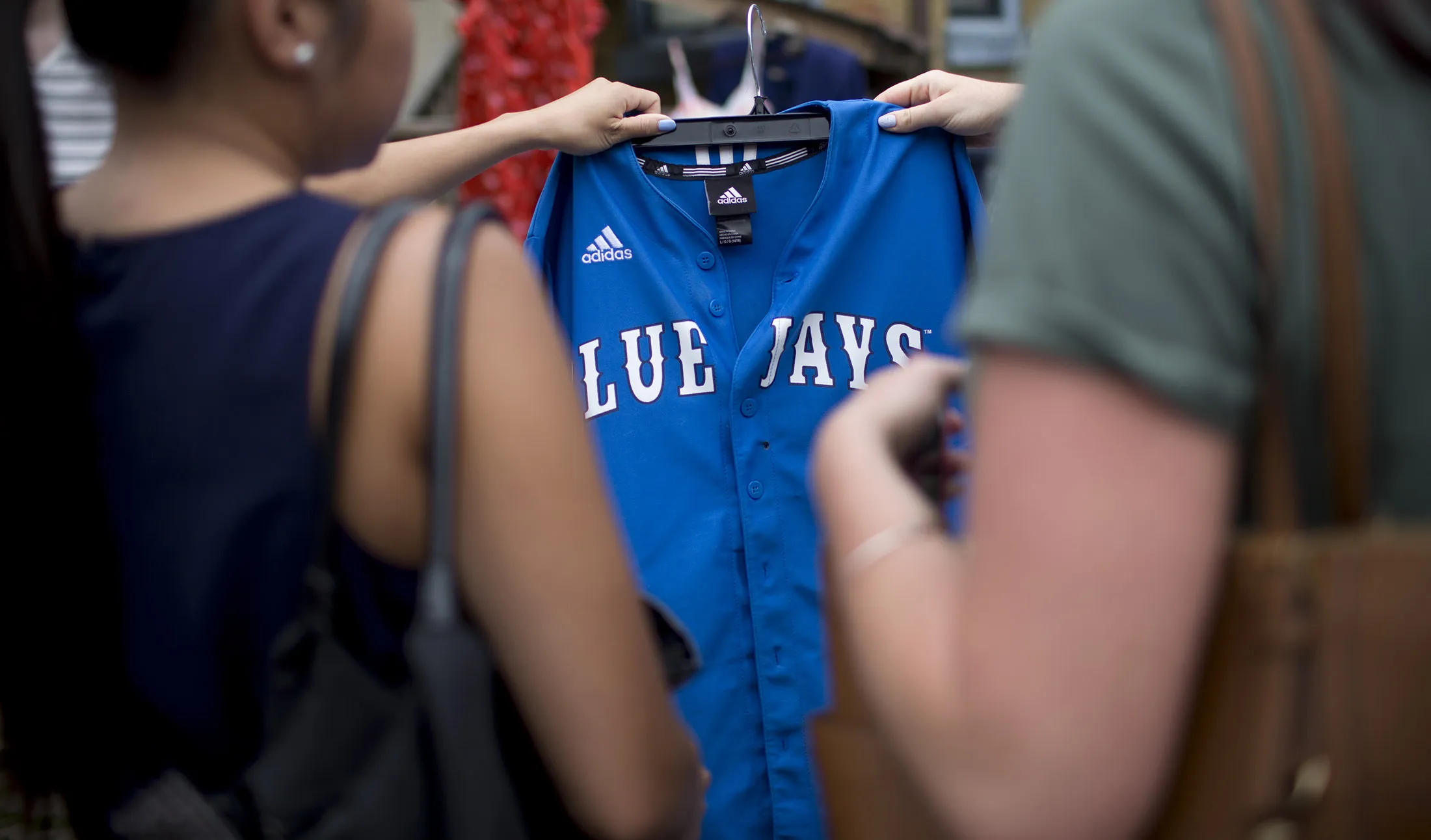Shoppers look at a Toronto Blue Jays jersey in Kensington Market in Toronto, Canada.
