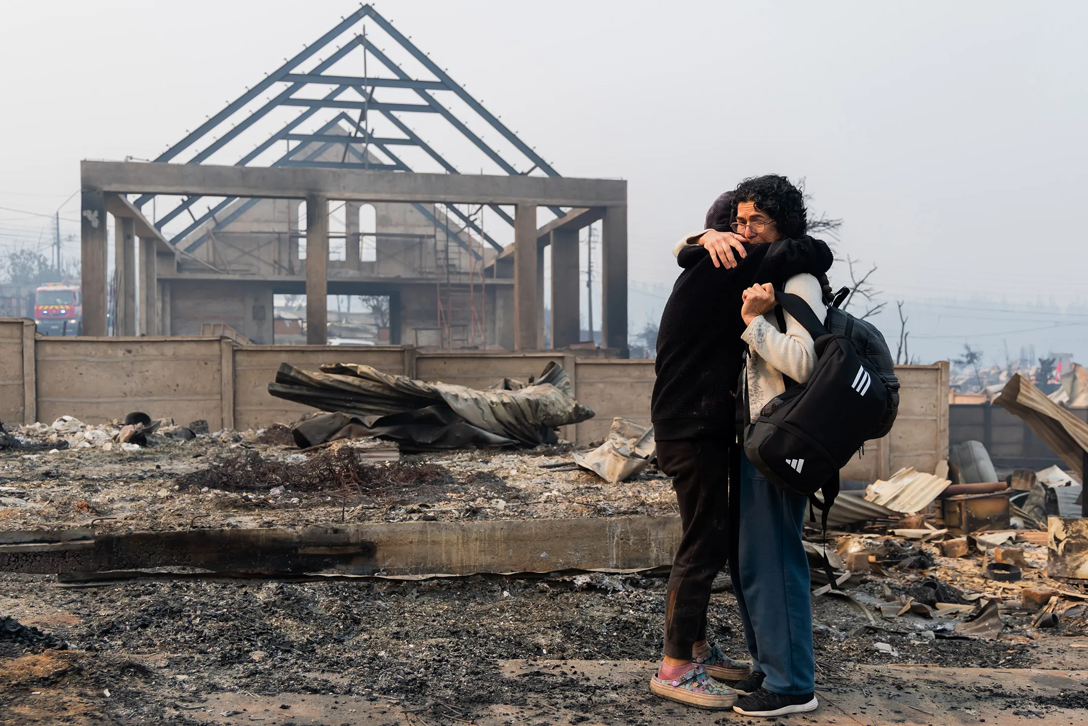 Mirtza Aguilera, right, and her daughter embrace in front of their home&nbsp;in Tomé, Chile, on Jan. 19, 2026.&nbsp;